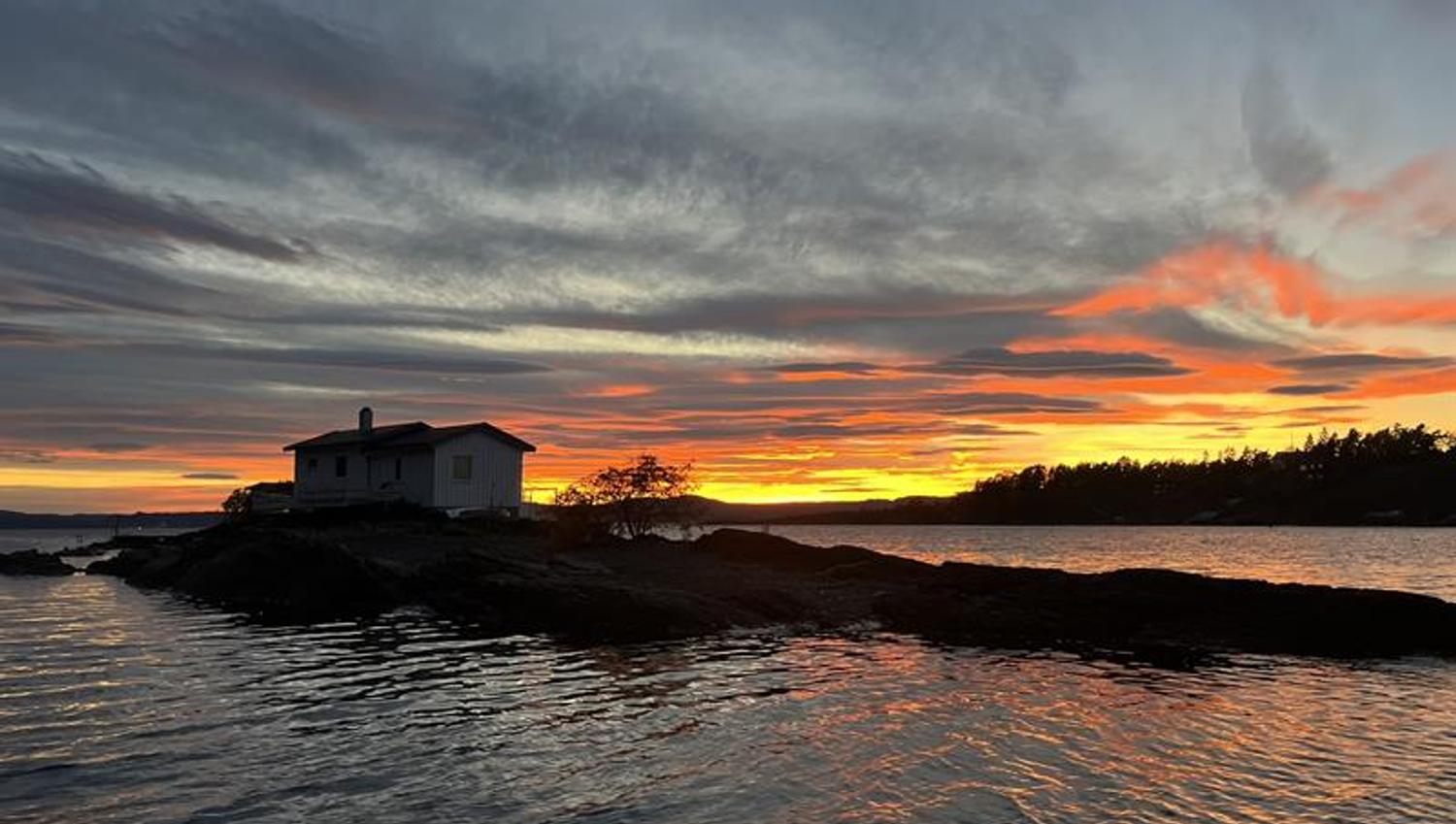 Solnedgang på fjorden med gul og rød himmel