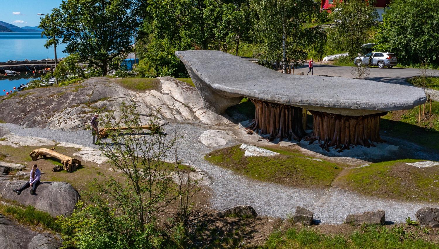 Bilde av Tyrvefjøra, en unik rasteplass formet som en omvendt båt, omgitt av skandinavisk landskap med utsikt over en fjord og fjell i Norge.