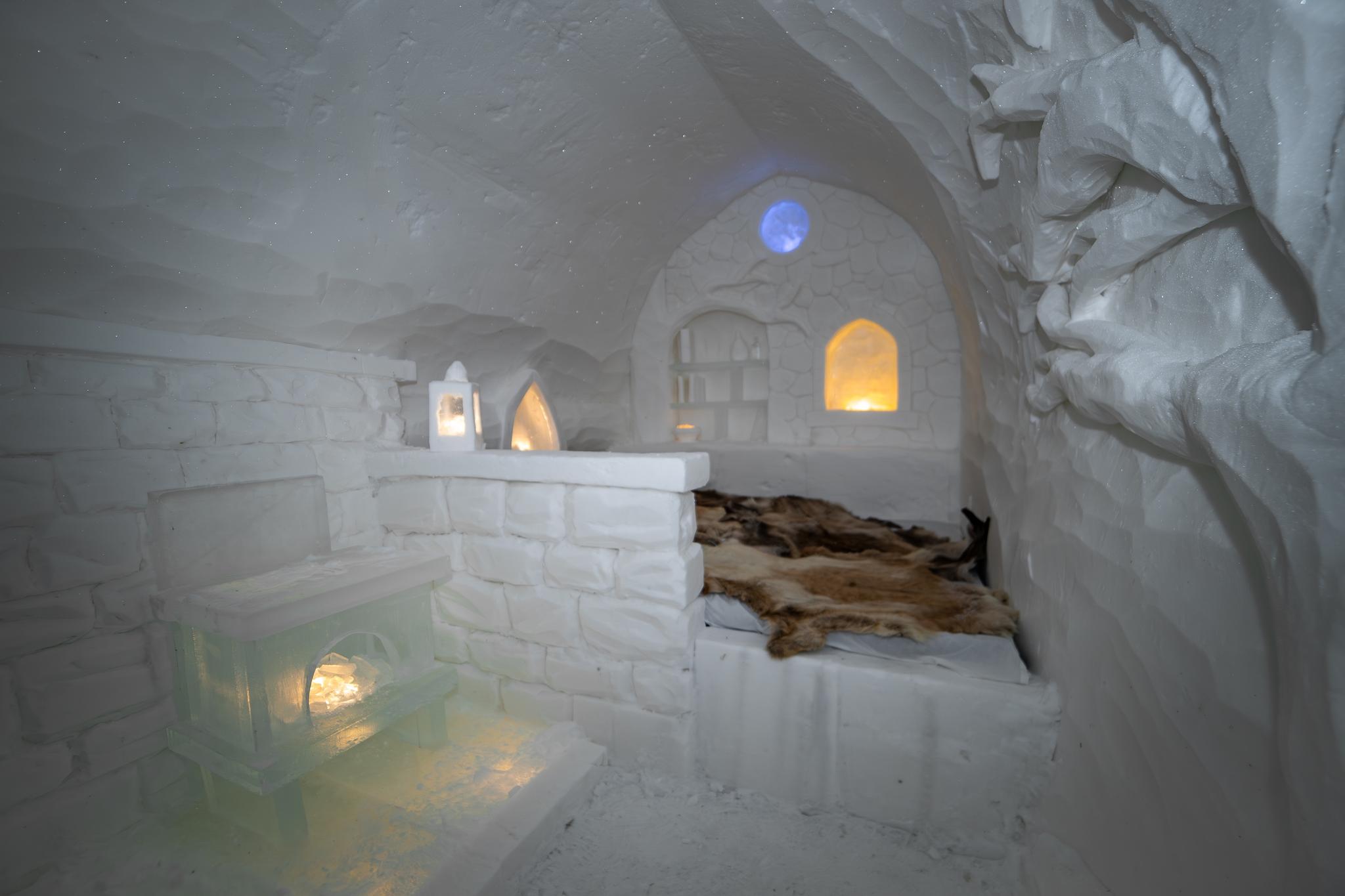 Step into this enchanting ice cave, where cozy illumination and carved ice furnishings create a magical atmosphere. Perfect for winter adventures or unique art displays, this frosty retreat invites you to experience a winter wonderland like no other.