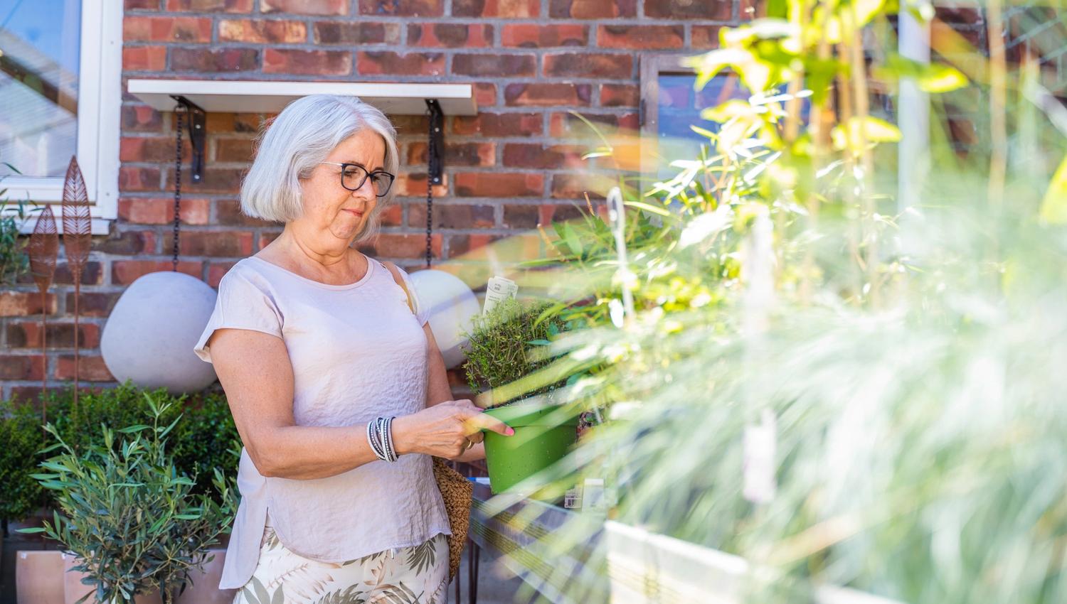 en dame som ser på planter