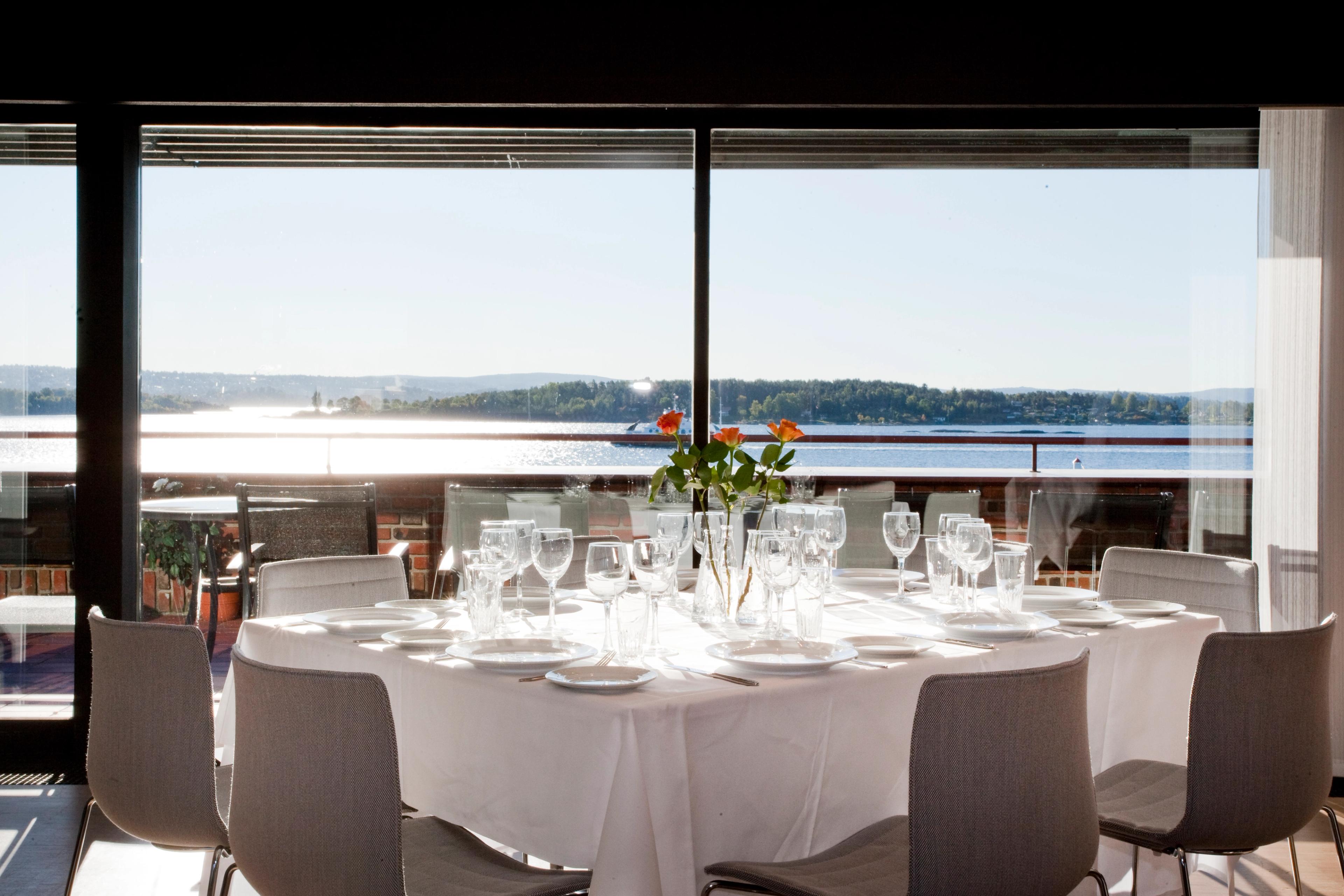 Dekket bord i restaurant med utsikt over fjorden