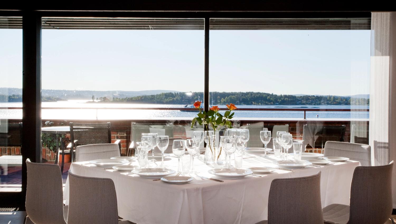 Dekket bord i restaurant med utsikt over fjorden