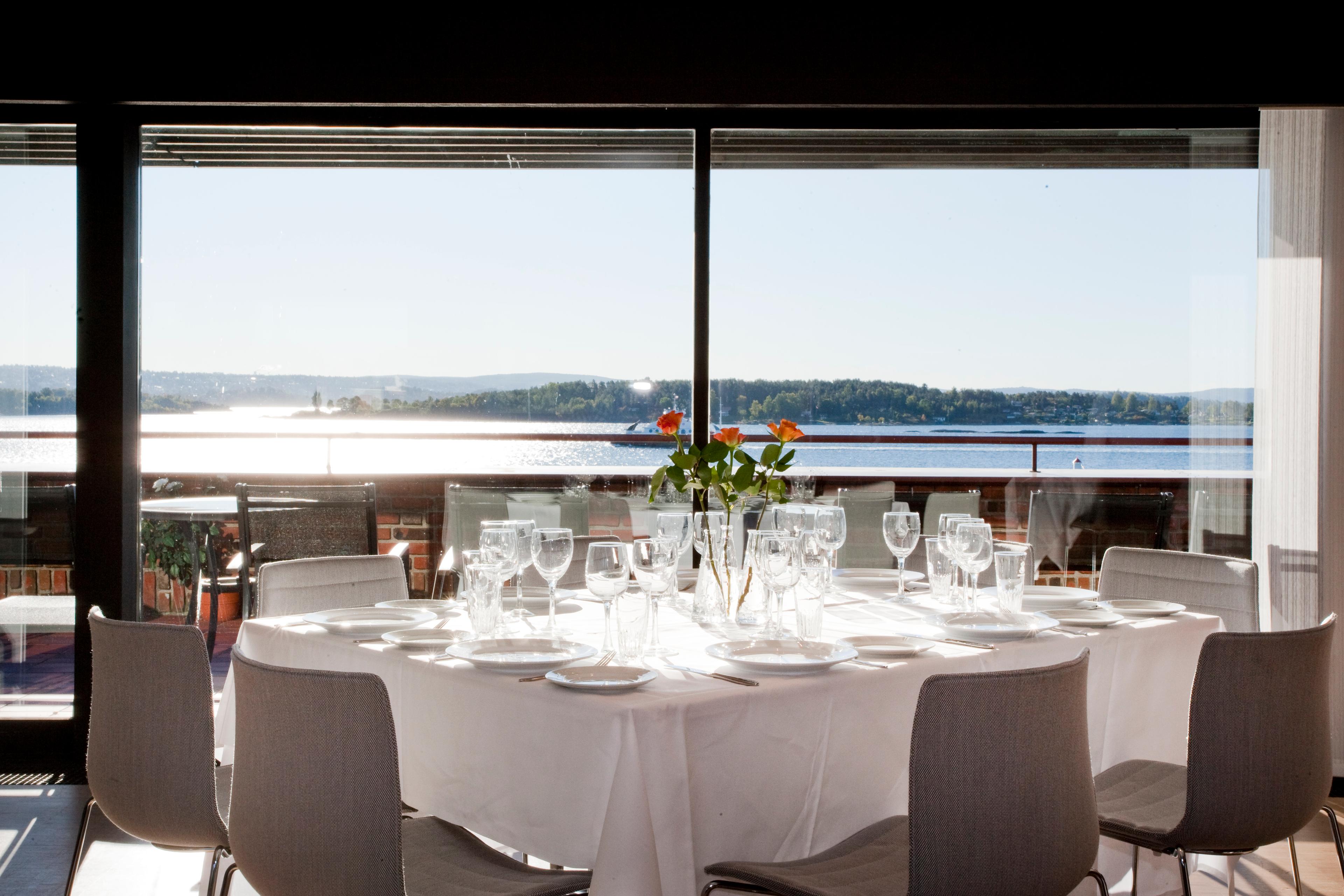 Dekket bord i restaurant med utsikt over fjorden