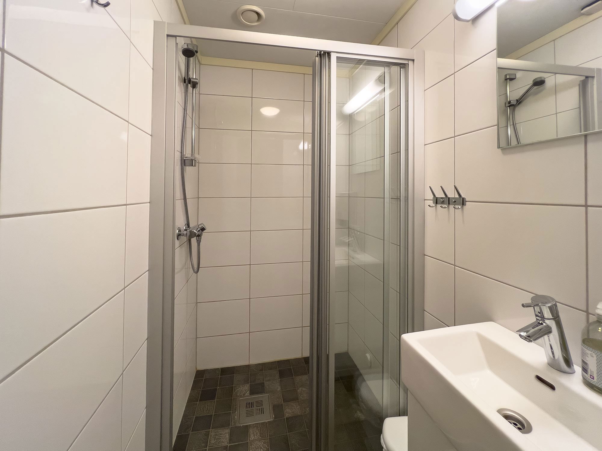 A bathroom with shower and sink.