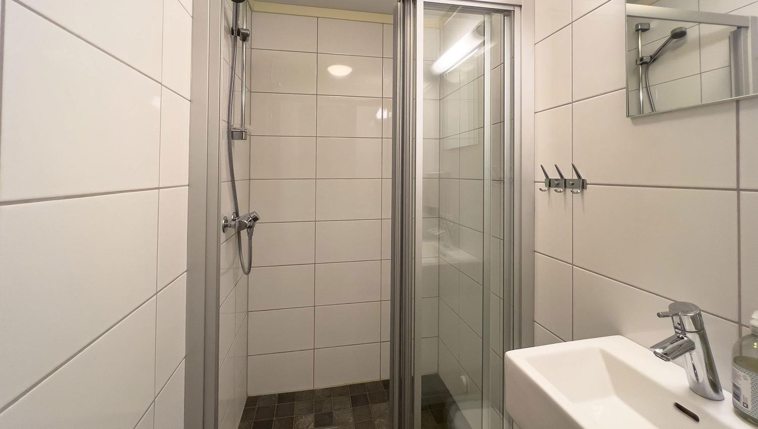A bathroom with shower and sink.
