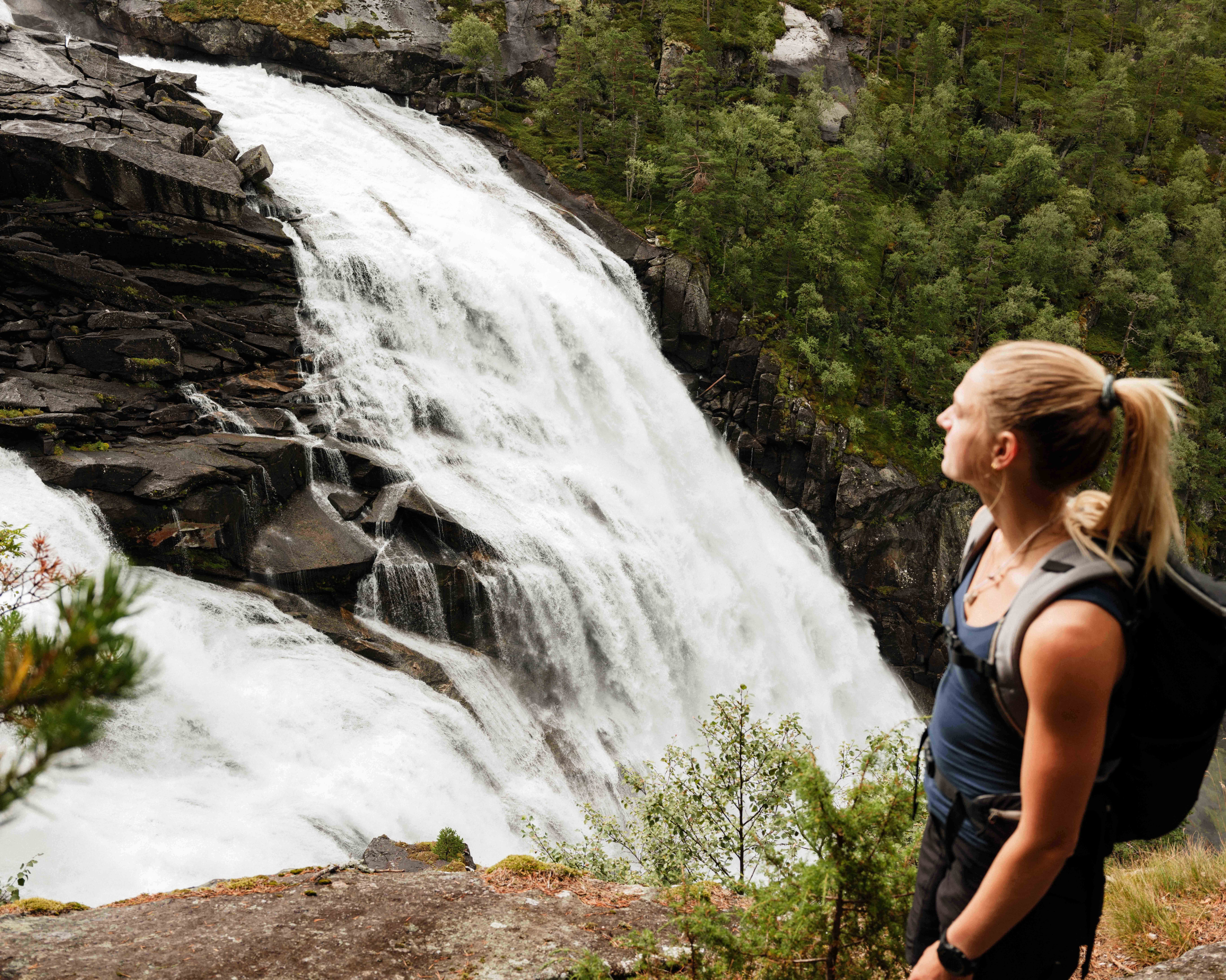 Nærbilete av turgåar med utsikt over Nykkjesøyfossen, ein av dei vakraste fossane i Husedalen.