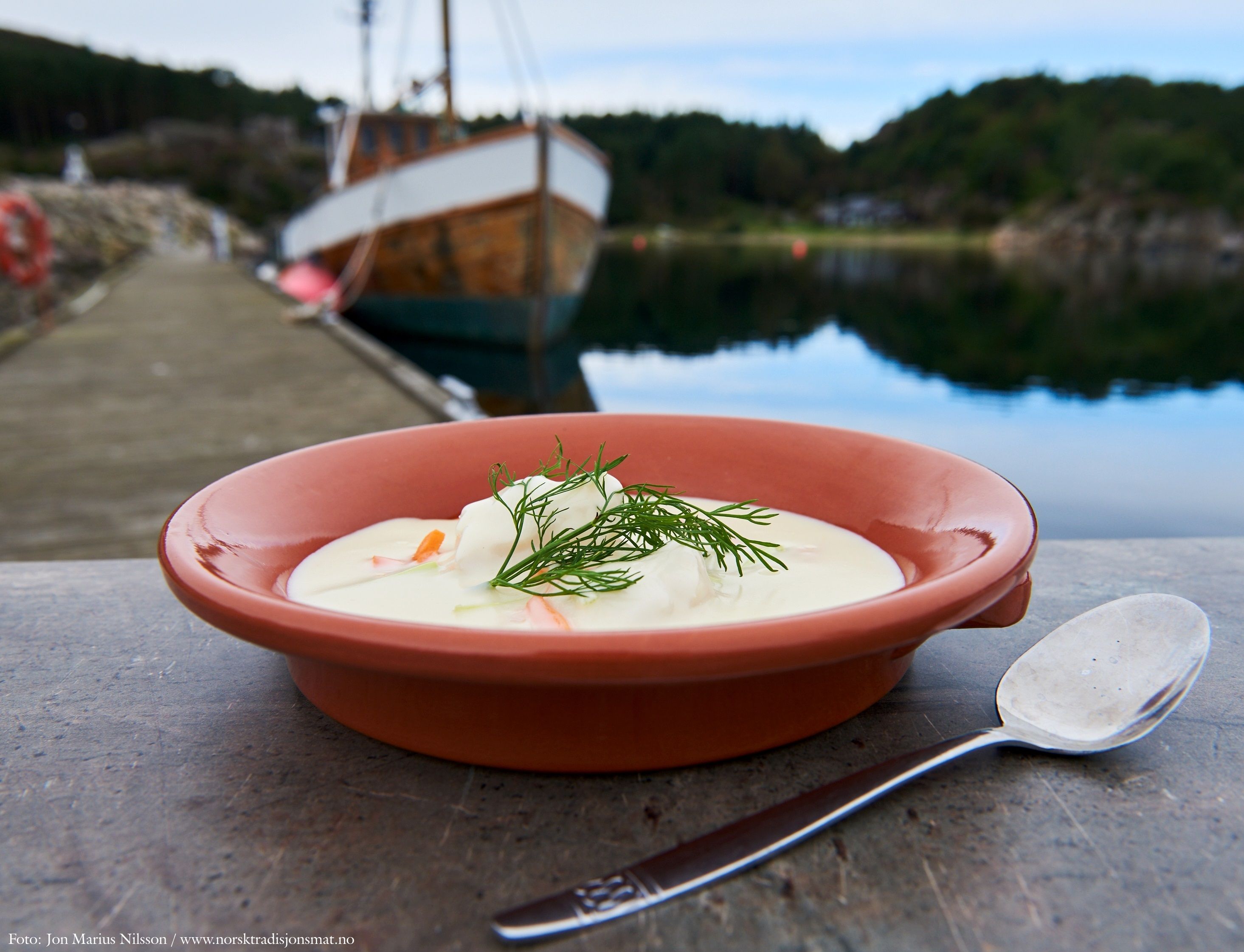 Fiskesuppe med dill til pynt i en oransje skål