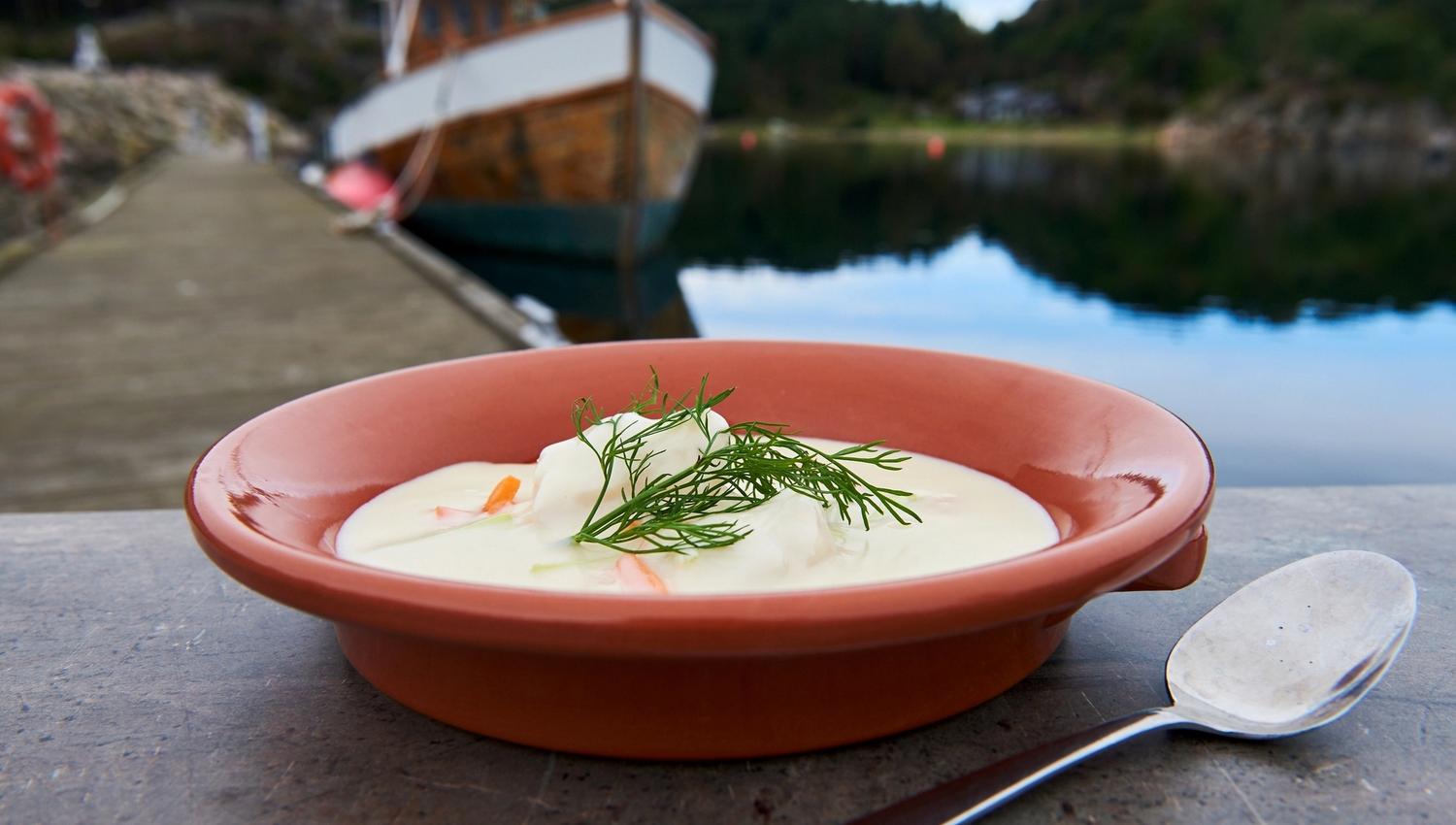 Fiskesuppe med dill til pynt i en oransje skål