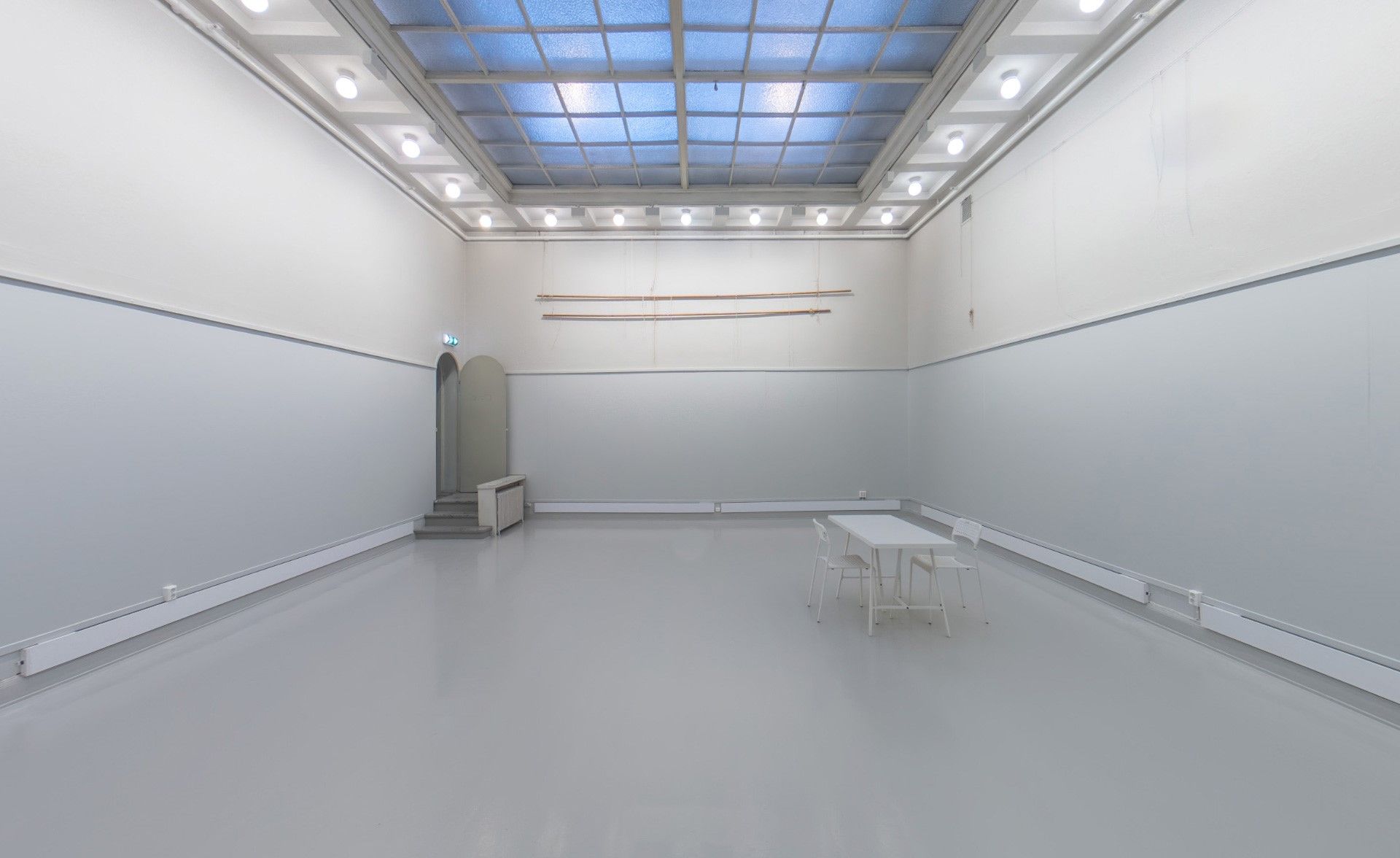 Large room with white walls and glass ceiling