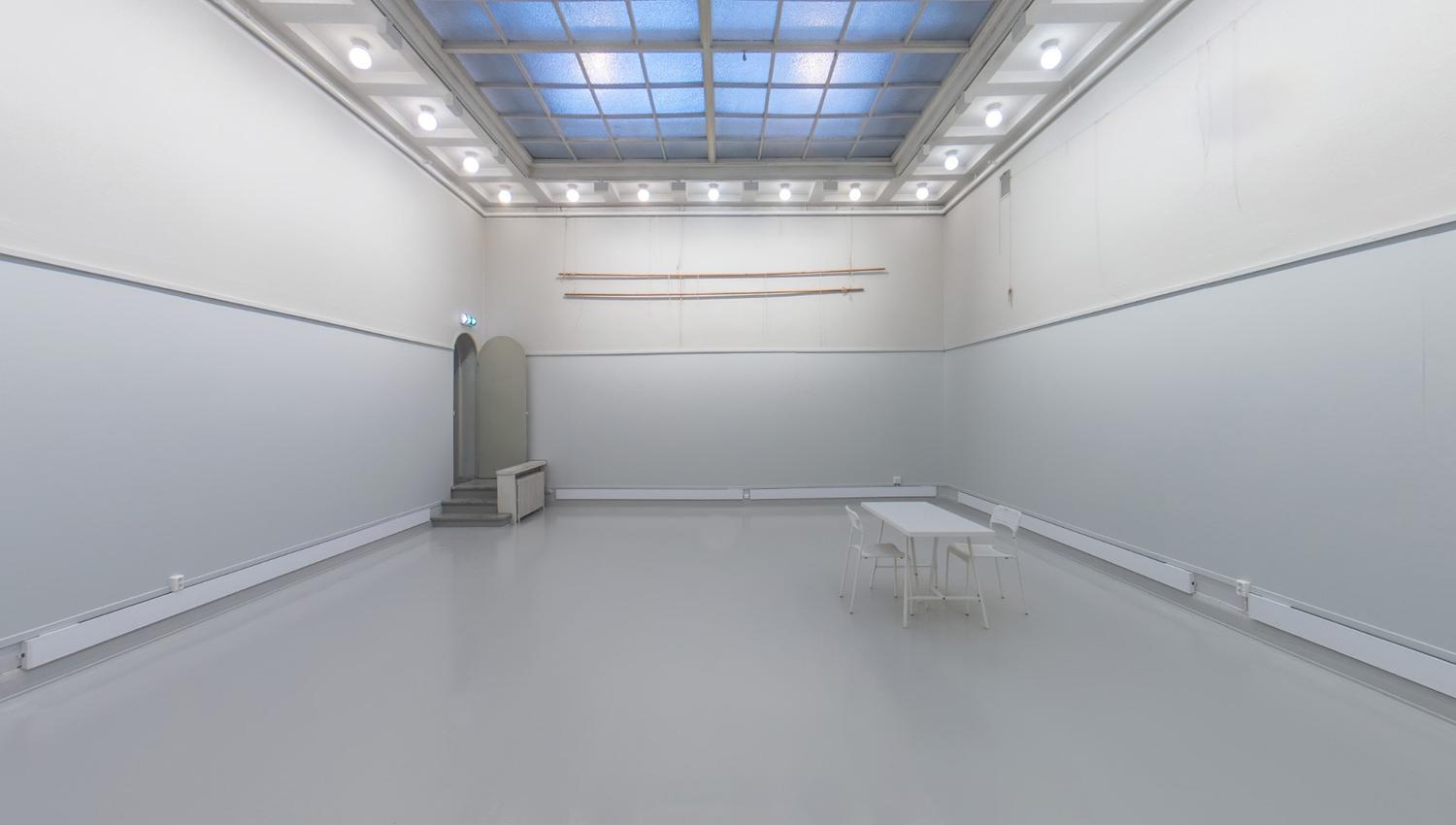 Large room with white walls and glass ceiling