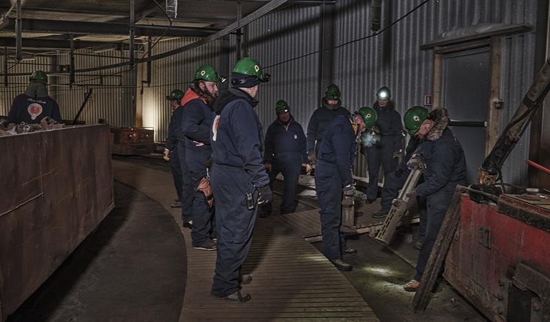 Guests on a guided tour of Mine 3 lifting and feeling the weight of mine pistons/pillars that were used there