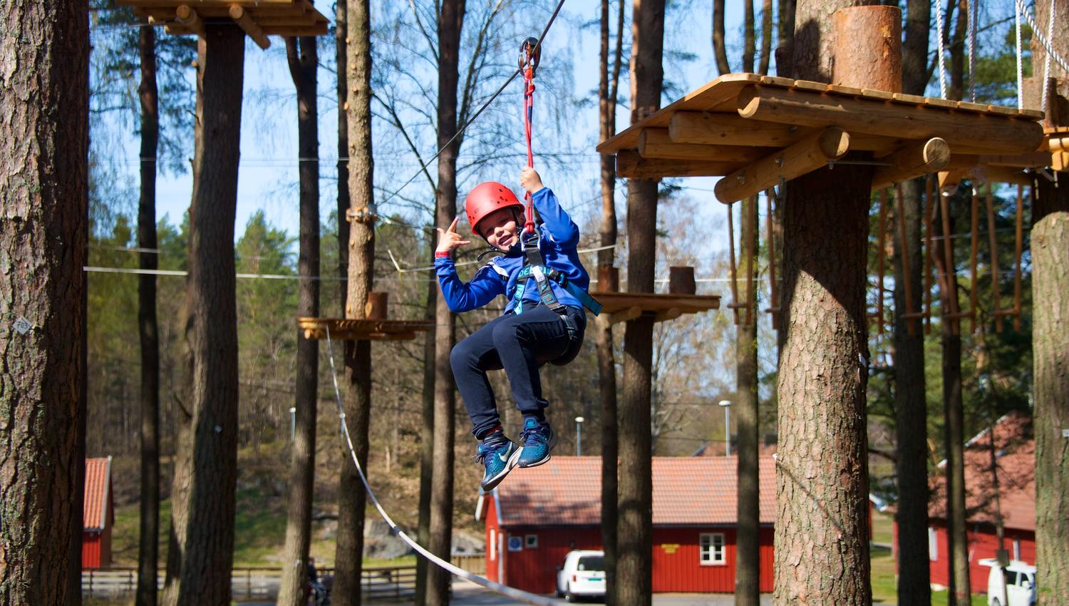 gutt suser avgårde i zipline i TrollPark Hove.