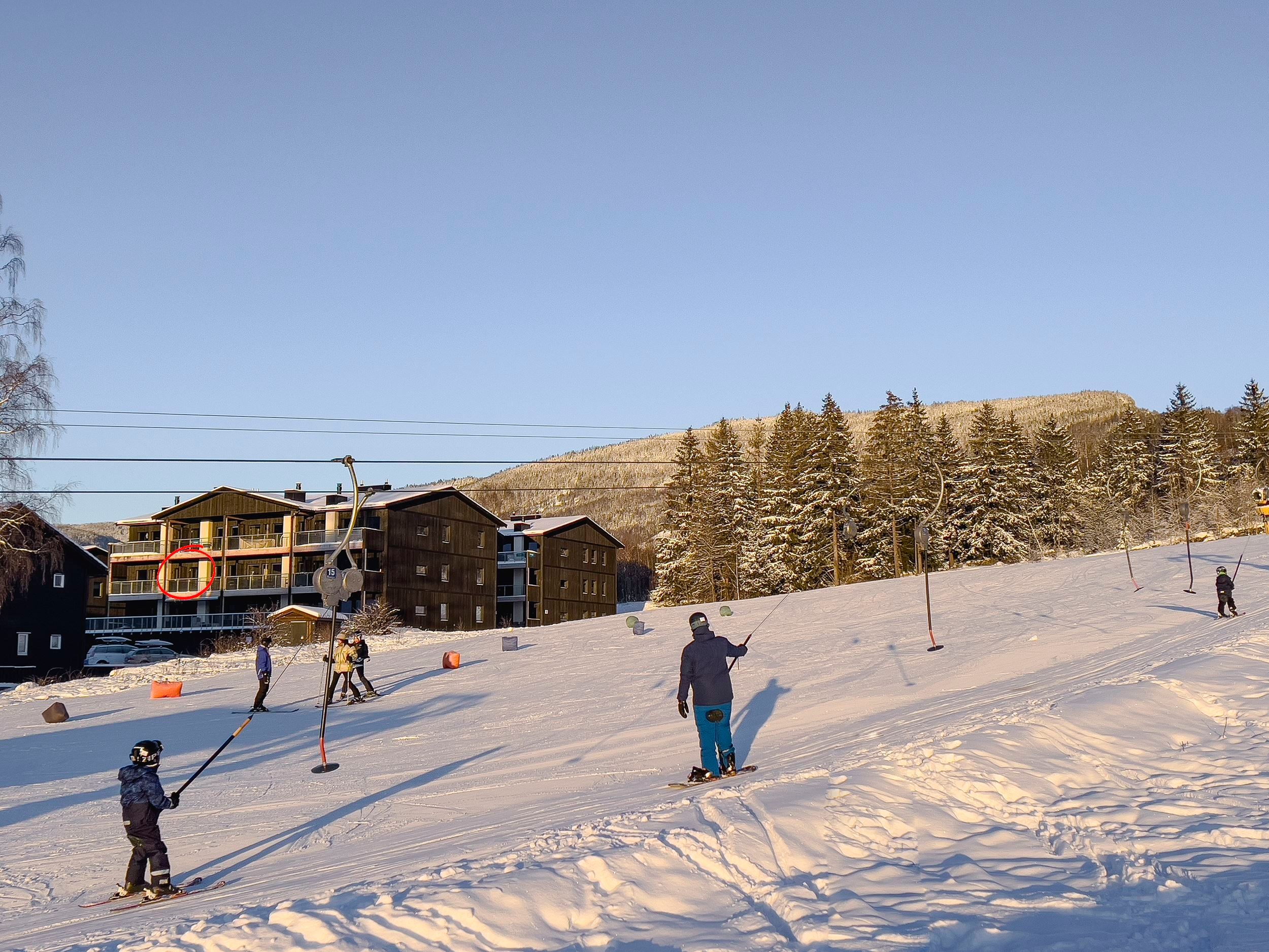 People snowboarding on a snow-covered hill.