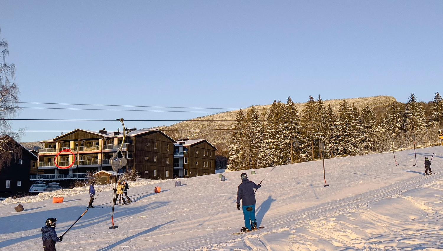 People snowboarding on a snow-covered hill.