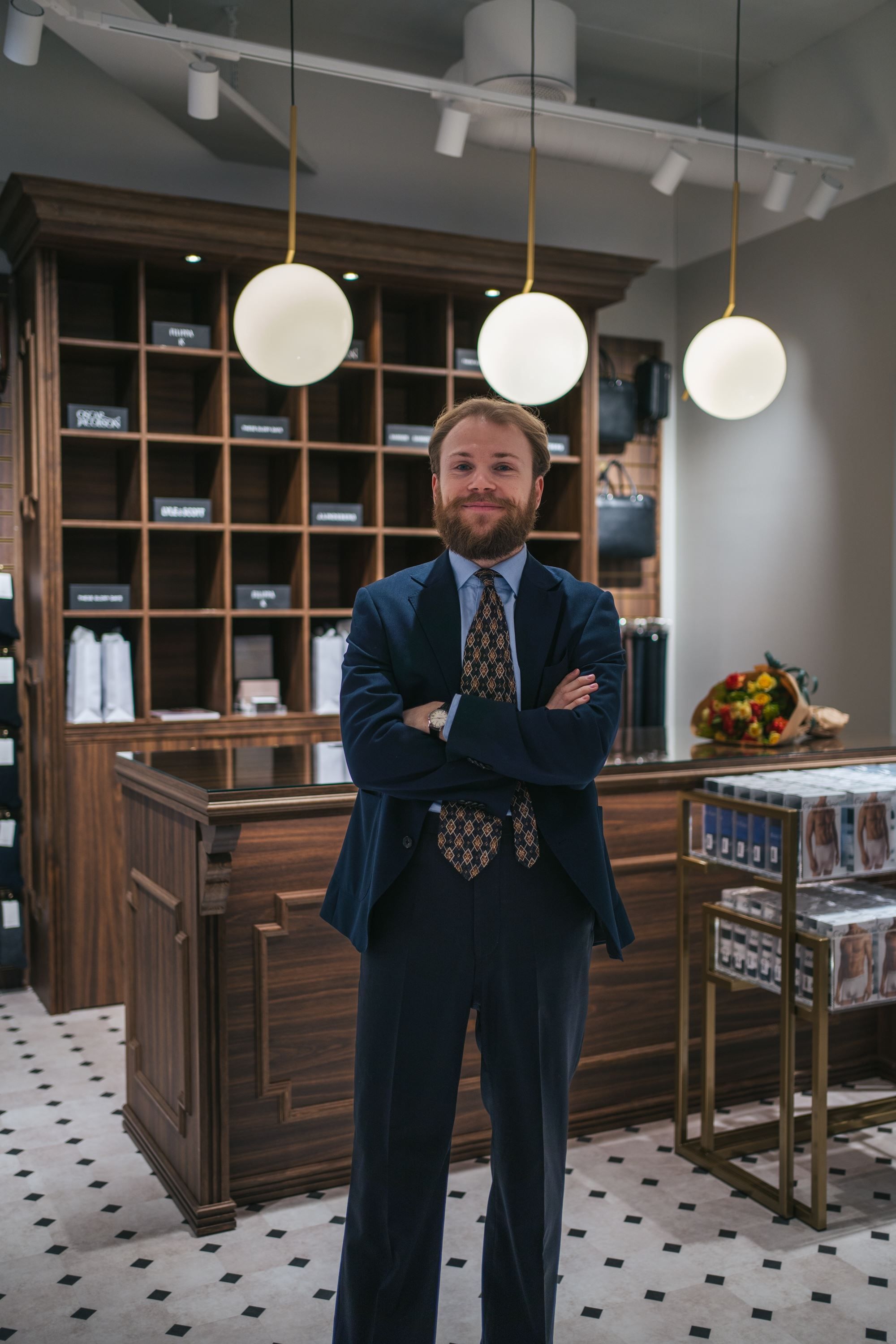 Ansatt poserer i butikken sin