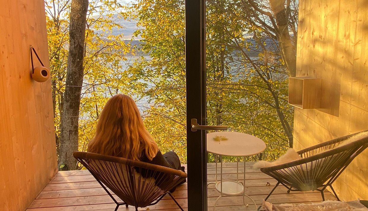 Guest enjoying the fjord view from the balcony in the cabin near Hardangerfjord.
