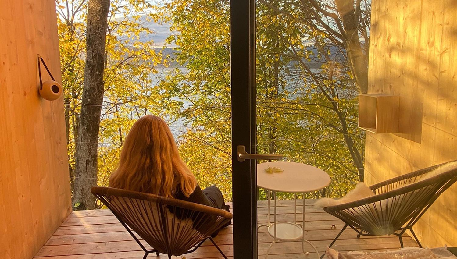 Guest enjoying the fjord view from the balcony in the cabin near Hardangerfjord.