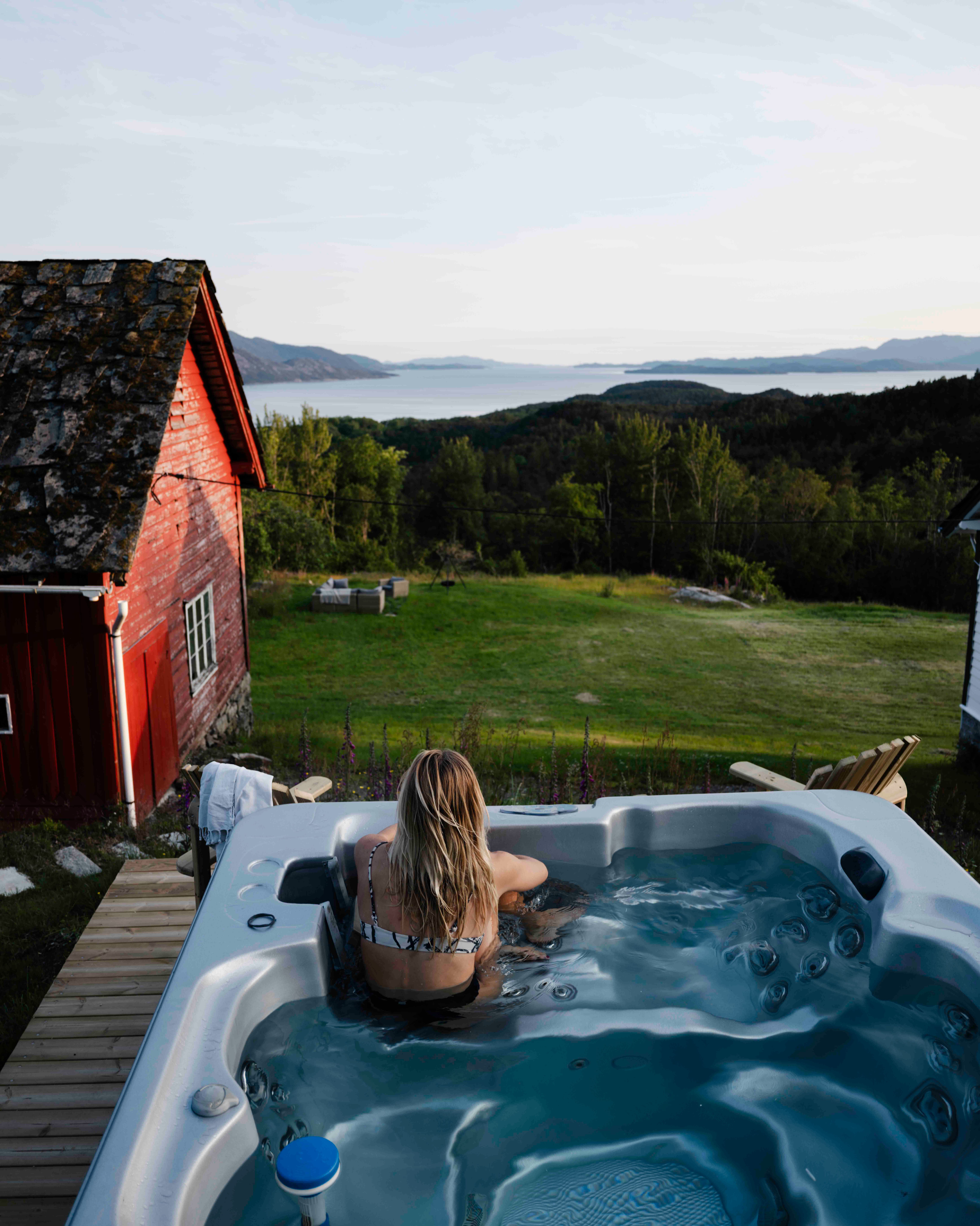 Kvinne slappar av i utespa med utsikt over Hardangerfjorden på Stigen Fjordlodge.
