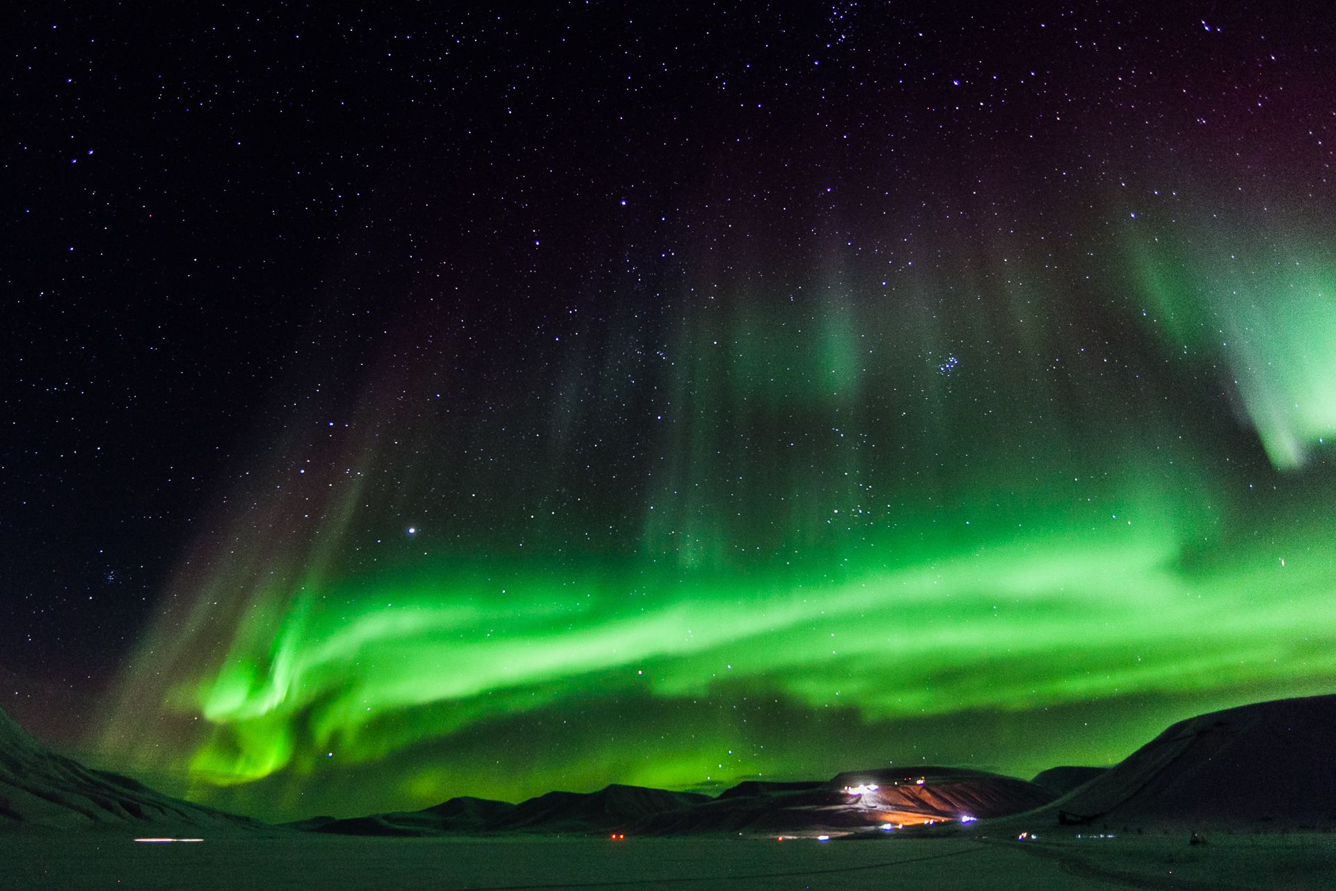 Nordlys som skinner på himmelen over en dal
