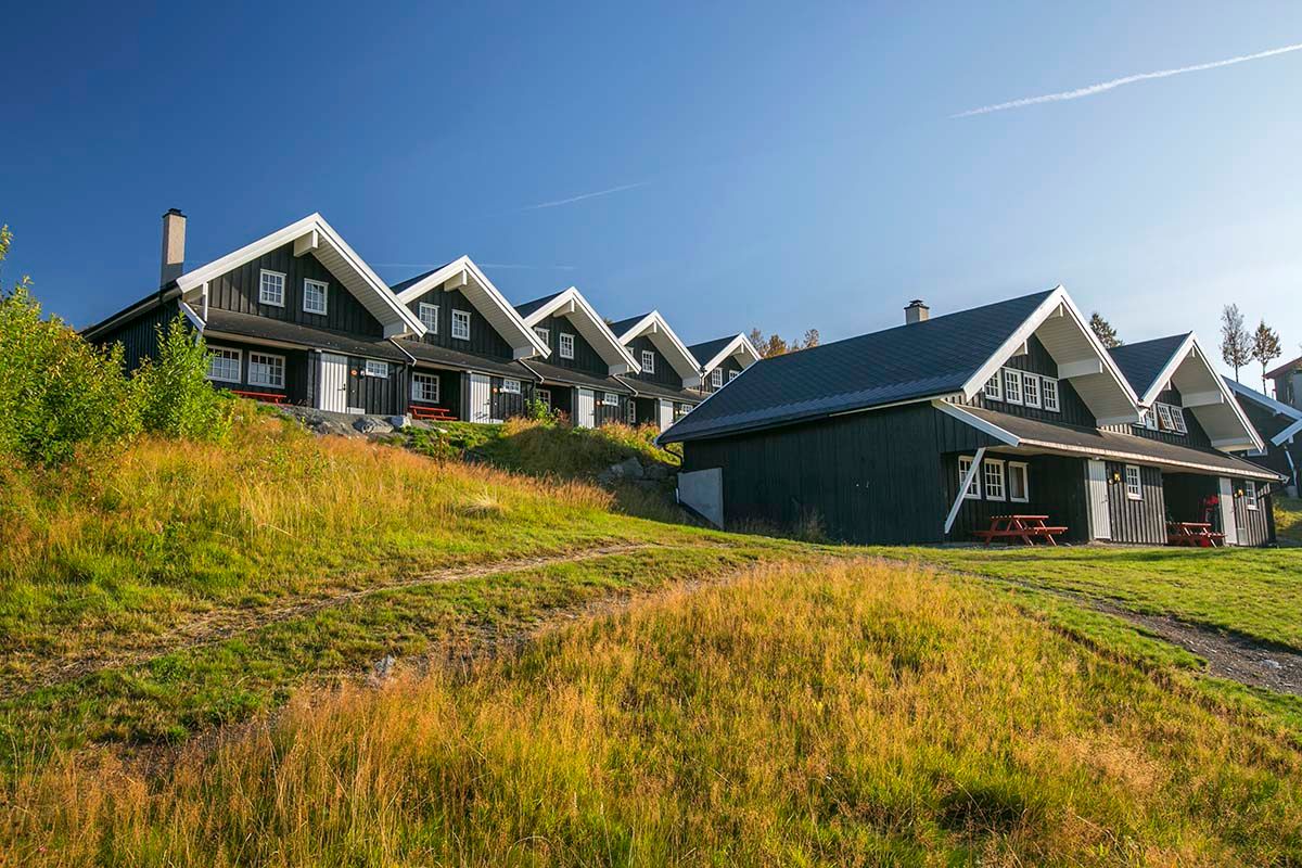 Bergo hytter med blå himmel og grønt gress