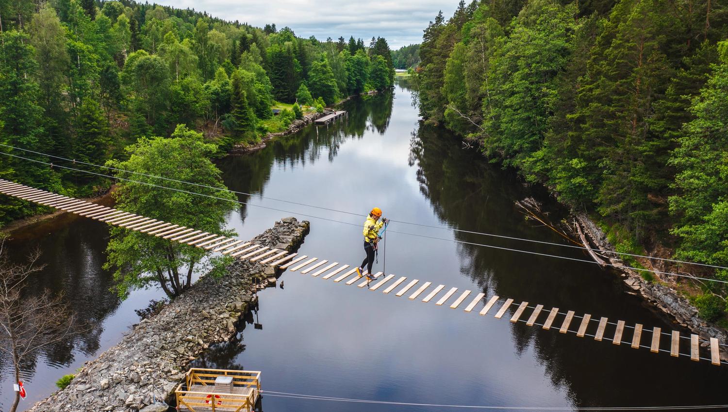 En person som krysser hengebroa, bildet er tatt fra lufta.