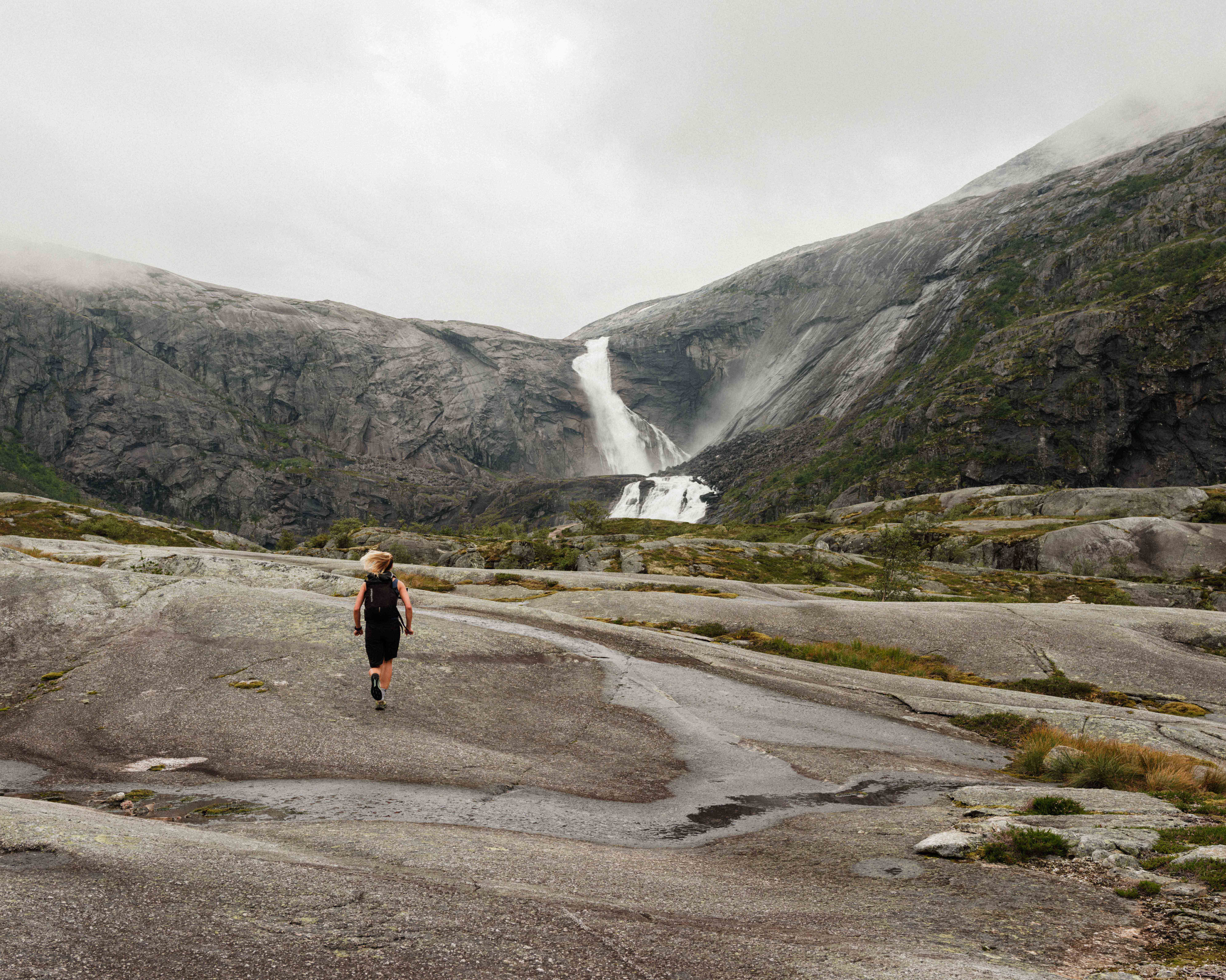Person joggar mot fossane i Husedalen.