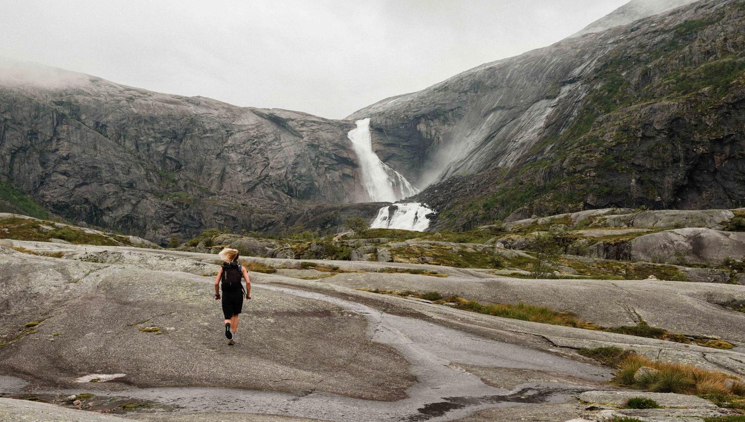 Person joggar mot fossane i Husedalen.