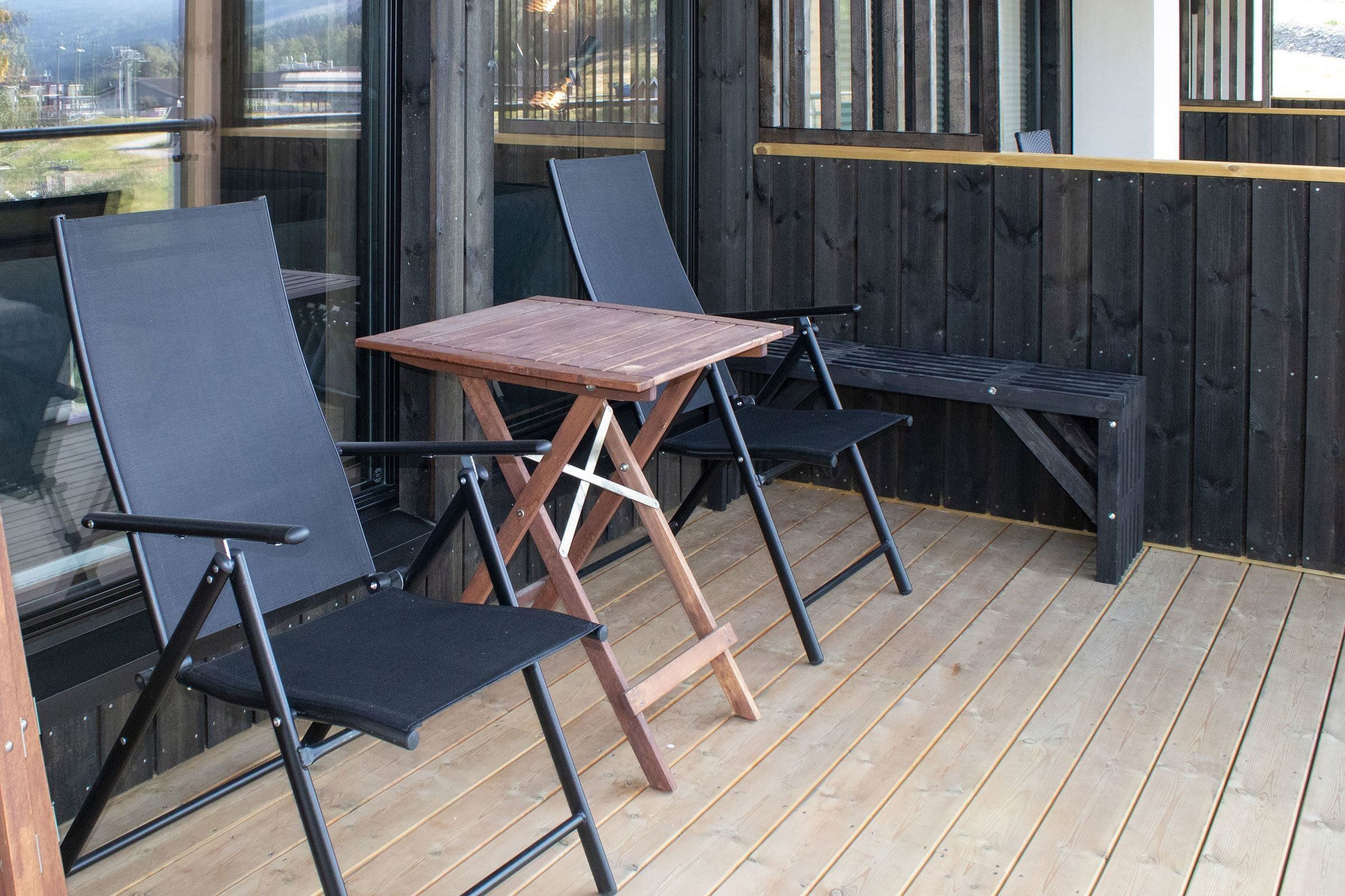 A table and chairs on a terrace.