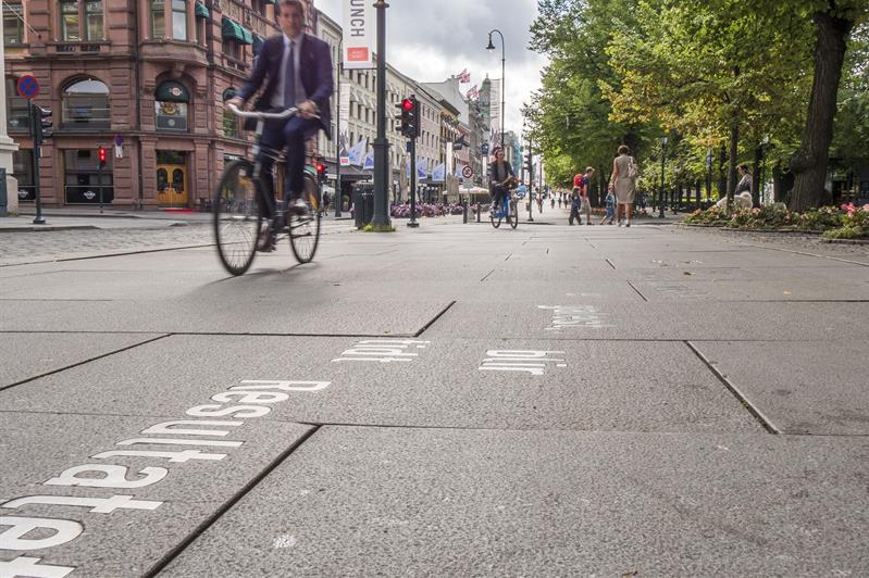 Syklister og fotgjengere som beveger seg langs Karl Johans gate.