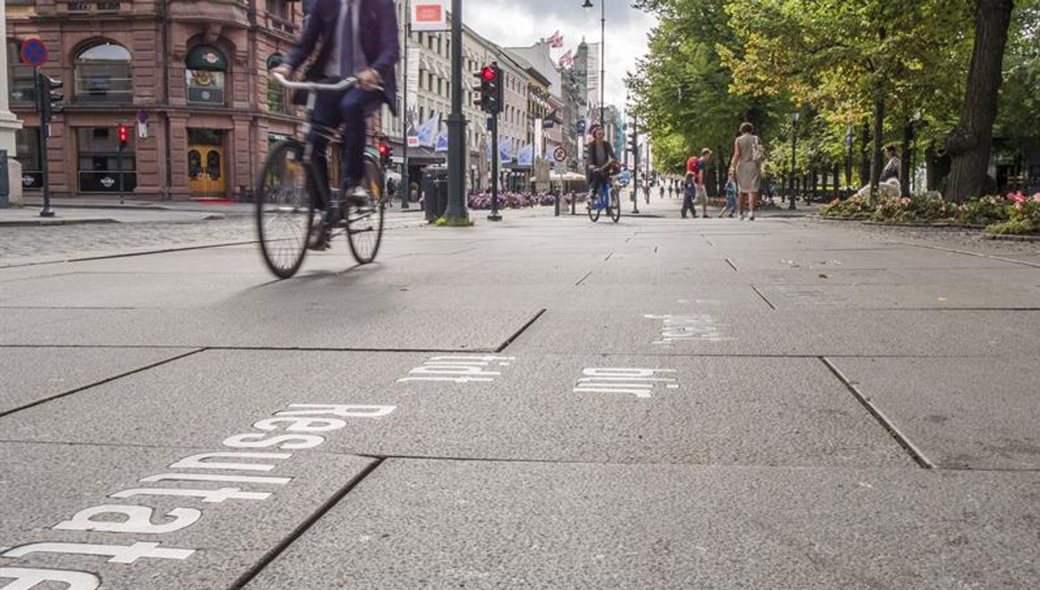 Syklister og fotgjengere som beveger seg langs Karl Johans gate.