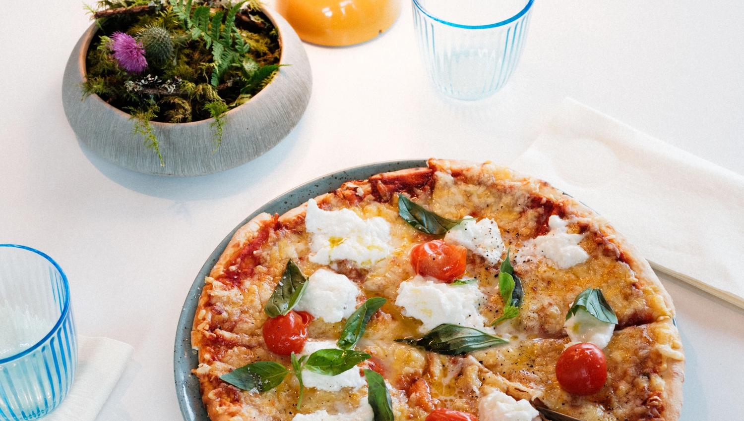 Steinomnsbakt pizza med fersk basilikum, cherrytomat og kremost på Gløyp Spiseri.
