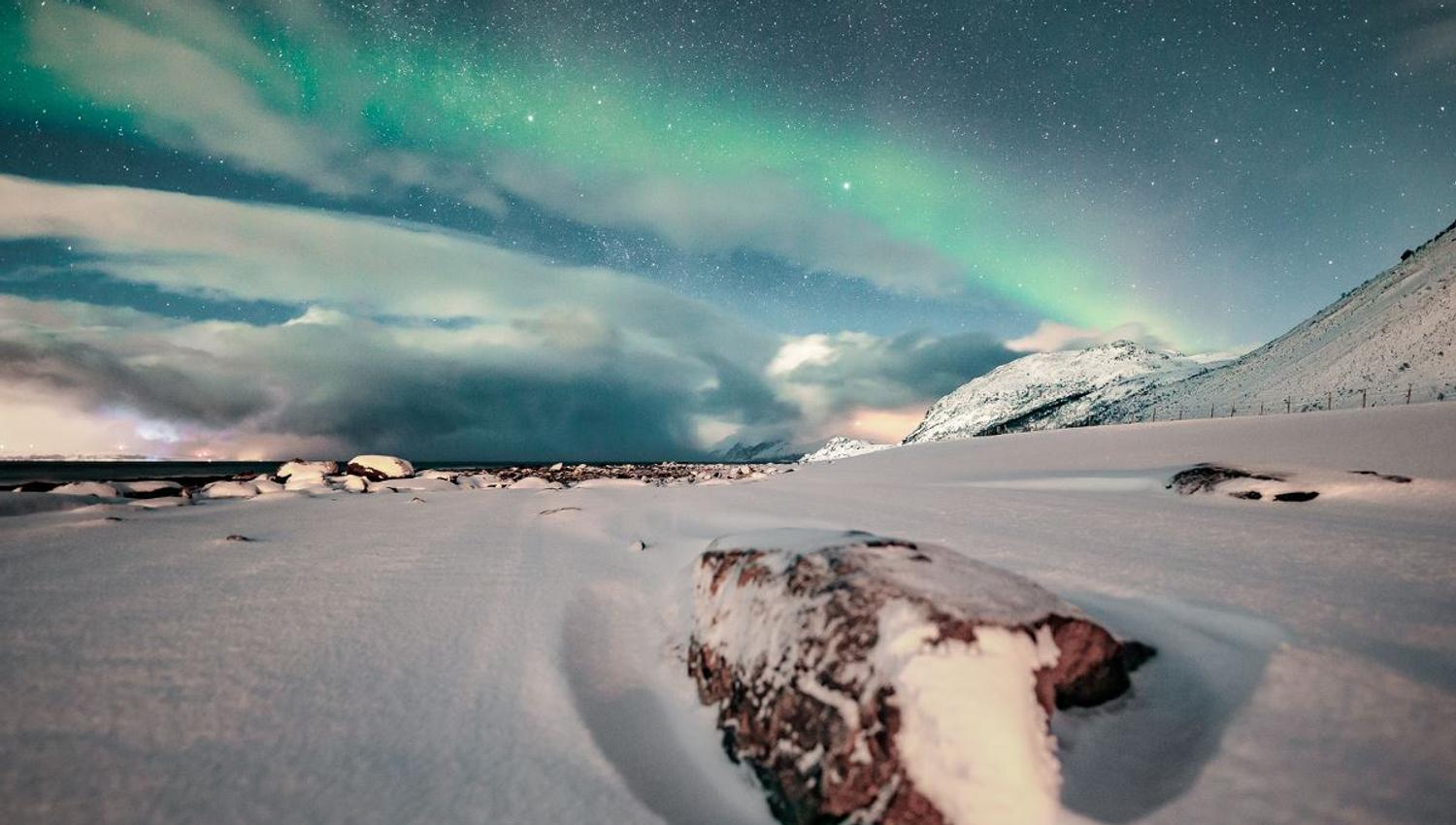 Nordlys og snødekt landskap