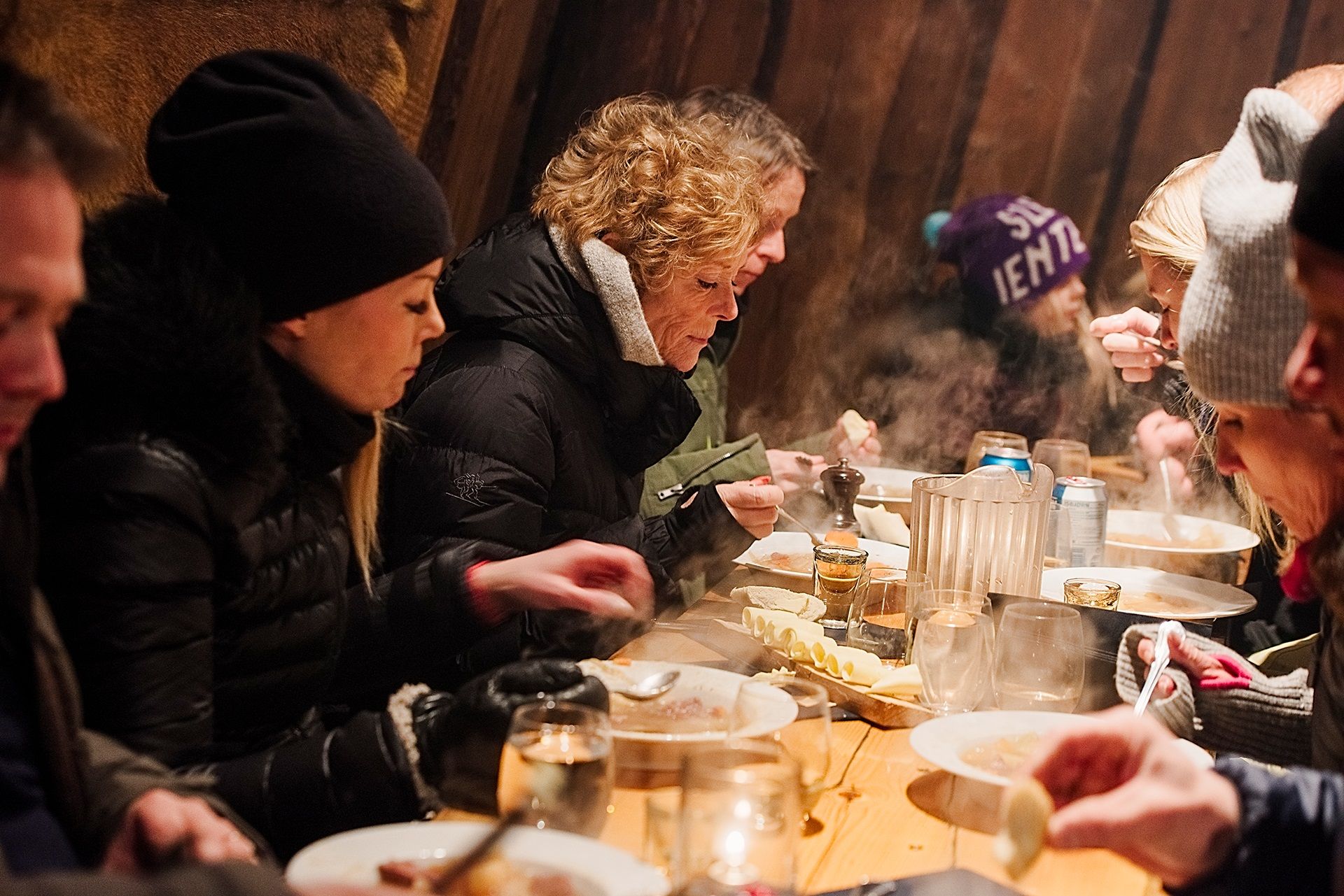 Guests eating dinner inside the cabin at Camp Barentz