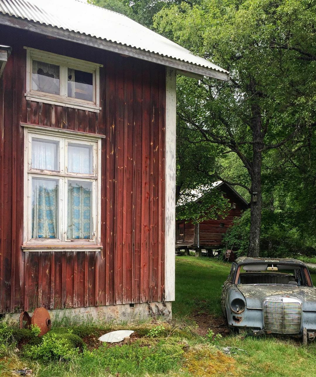 Rusten bil og gammelt hus