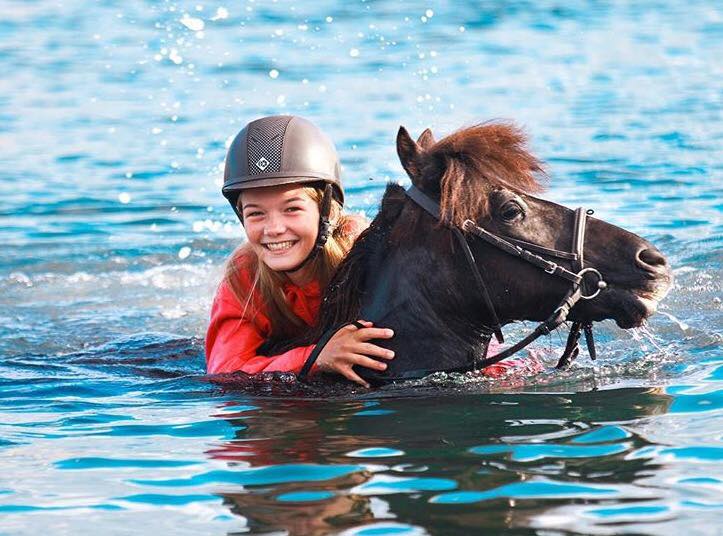 Hest og barn svømmer