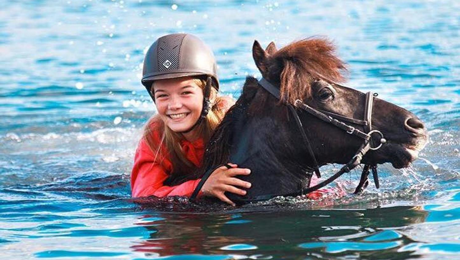 Hest og barn svømmer