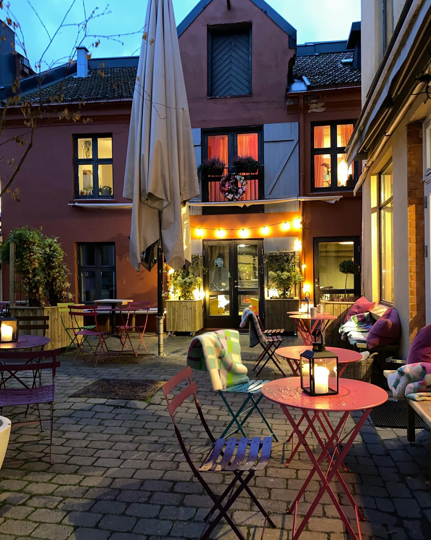 Bakgård med rosa bord og stoler