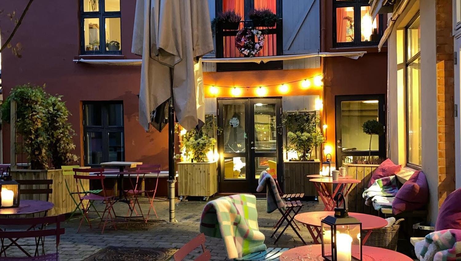 Bakgård med rosa bord og stoler