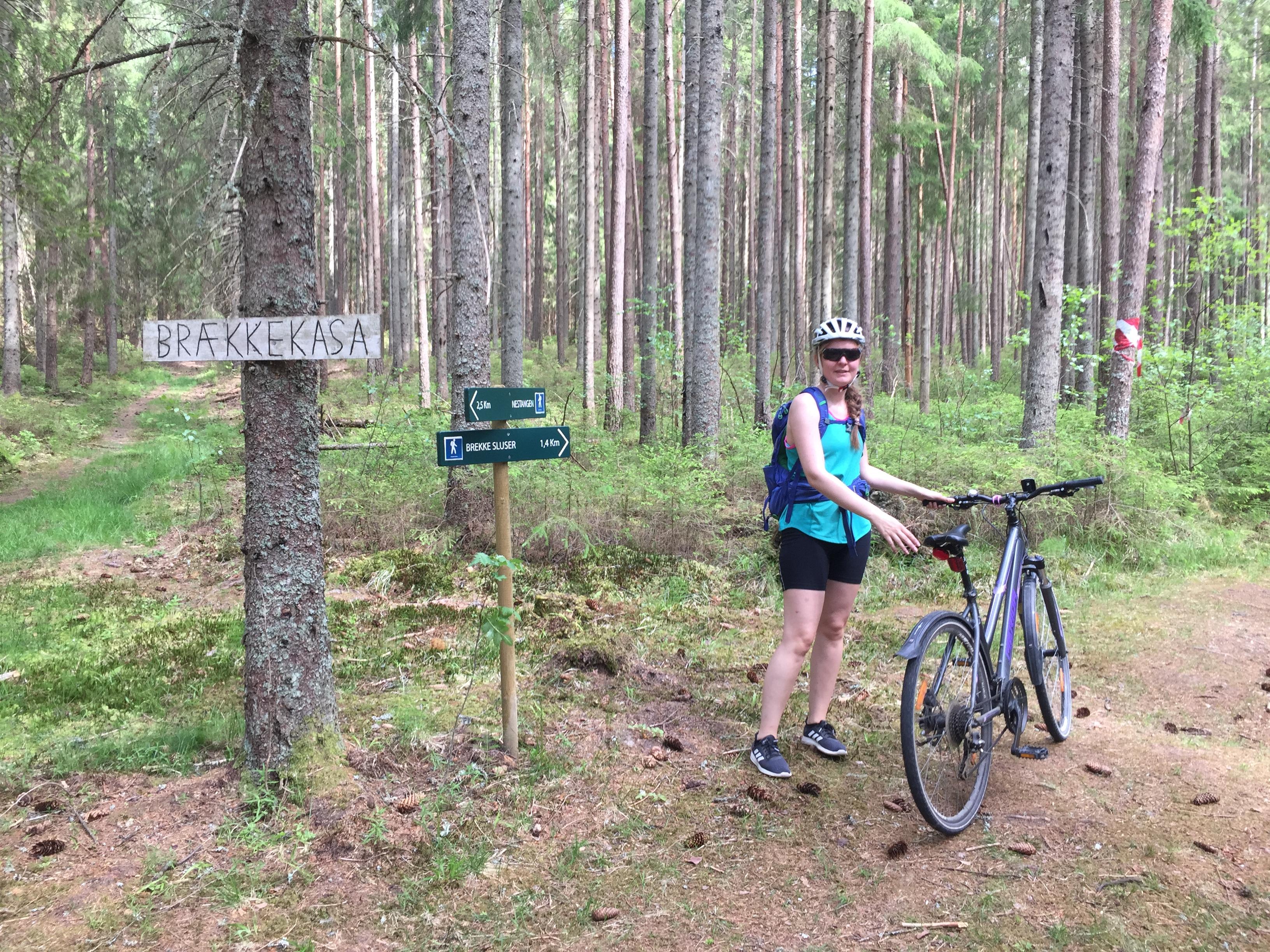 Dame med sykkel i skogen på stien ved Brækkekasa