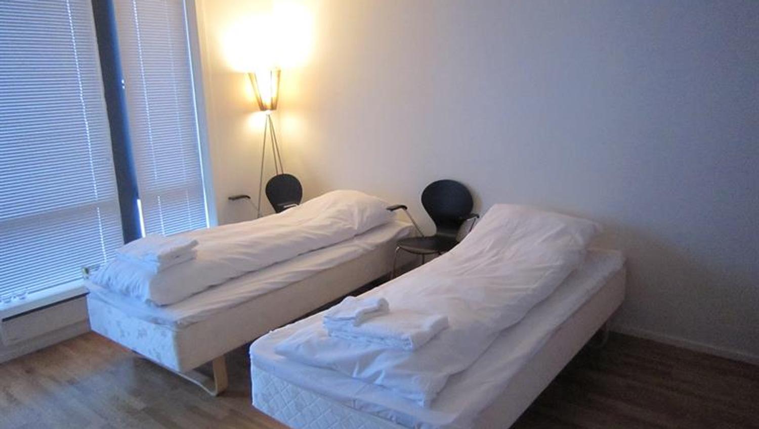 Lyst dobbeltrom på Hordatun Hotel, utstyrt med komfortable senger og moderne innreiing, perfekt for kvile etter aktivitetar i området.