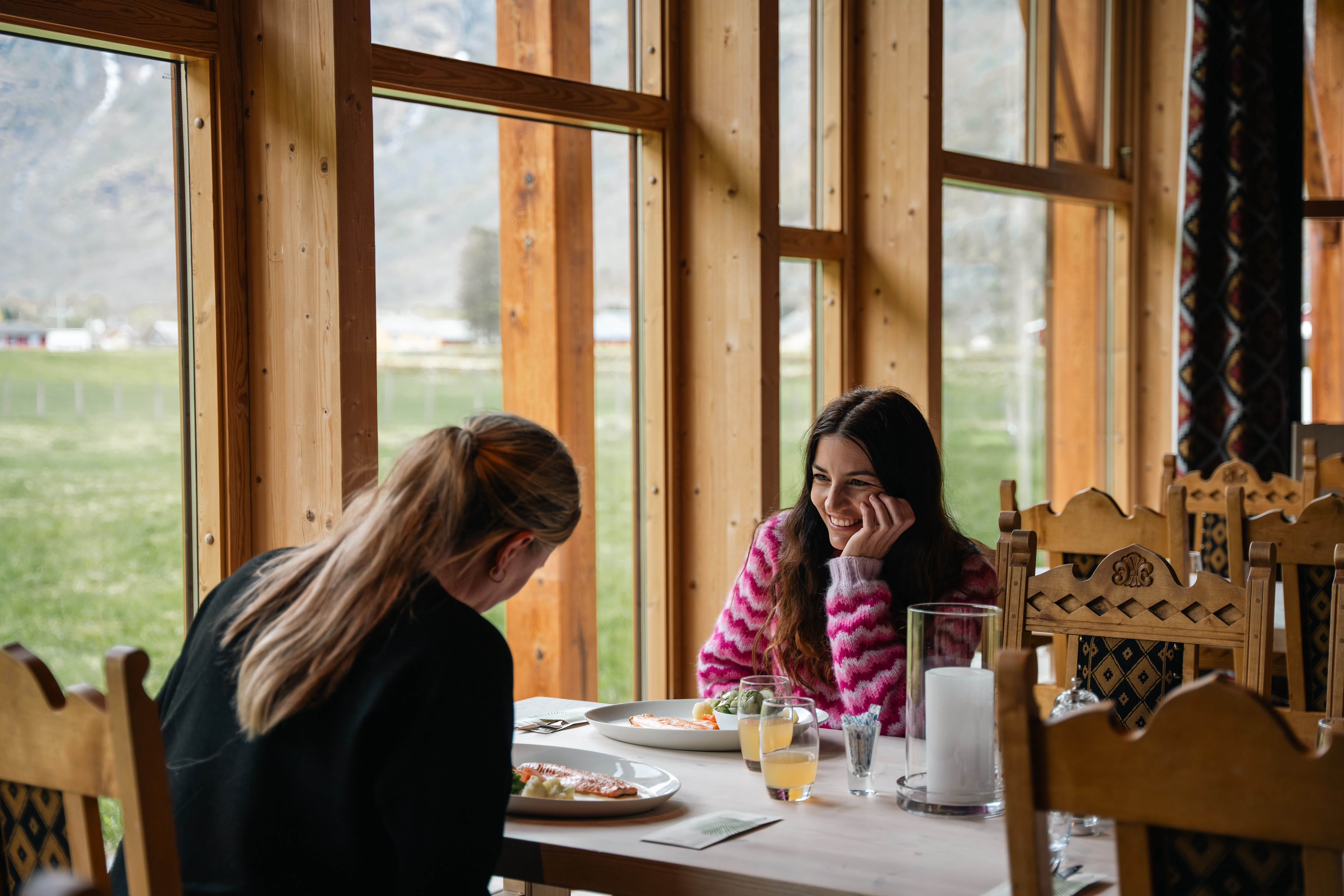 Two women eating mountain trout at a table with a view.