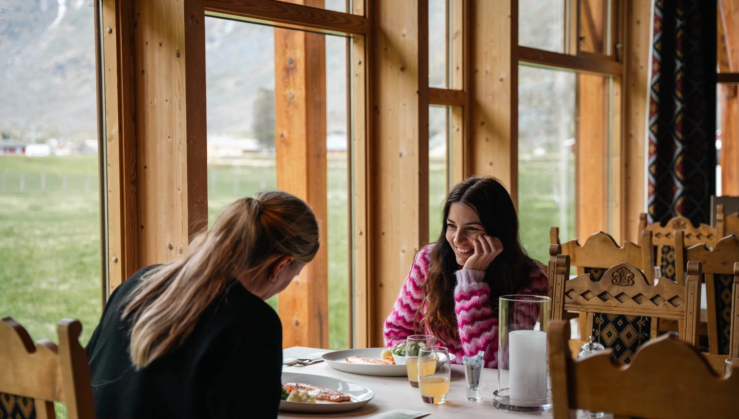 Two women eating mountain trout at a table with a view.