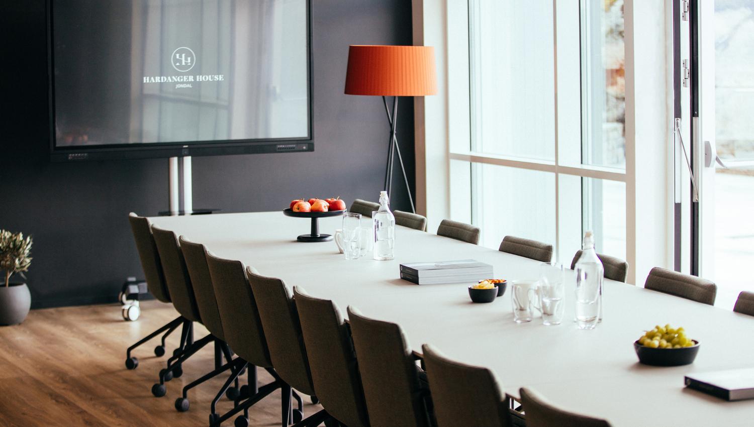 Conference room at Hardanger House with a long table and screen for meetings.