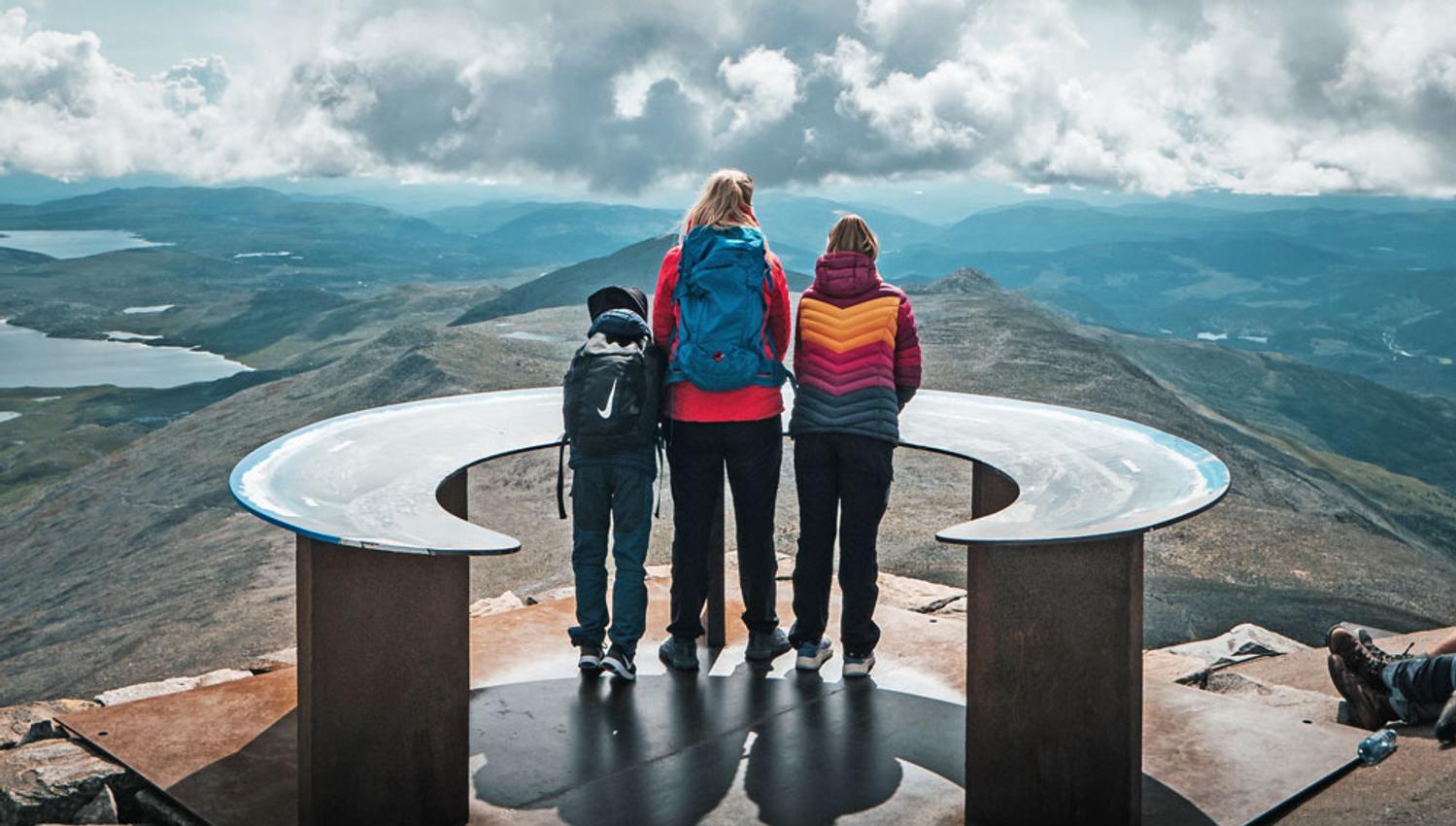 gruppe som står ved oversiktstavla på toppen av Gaustatoppen