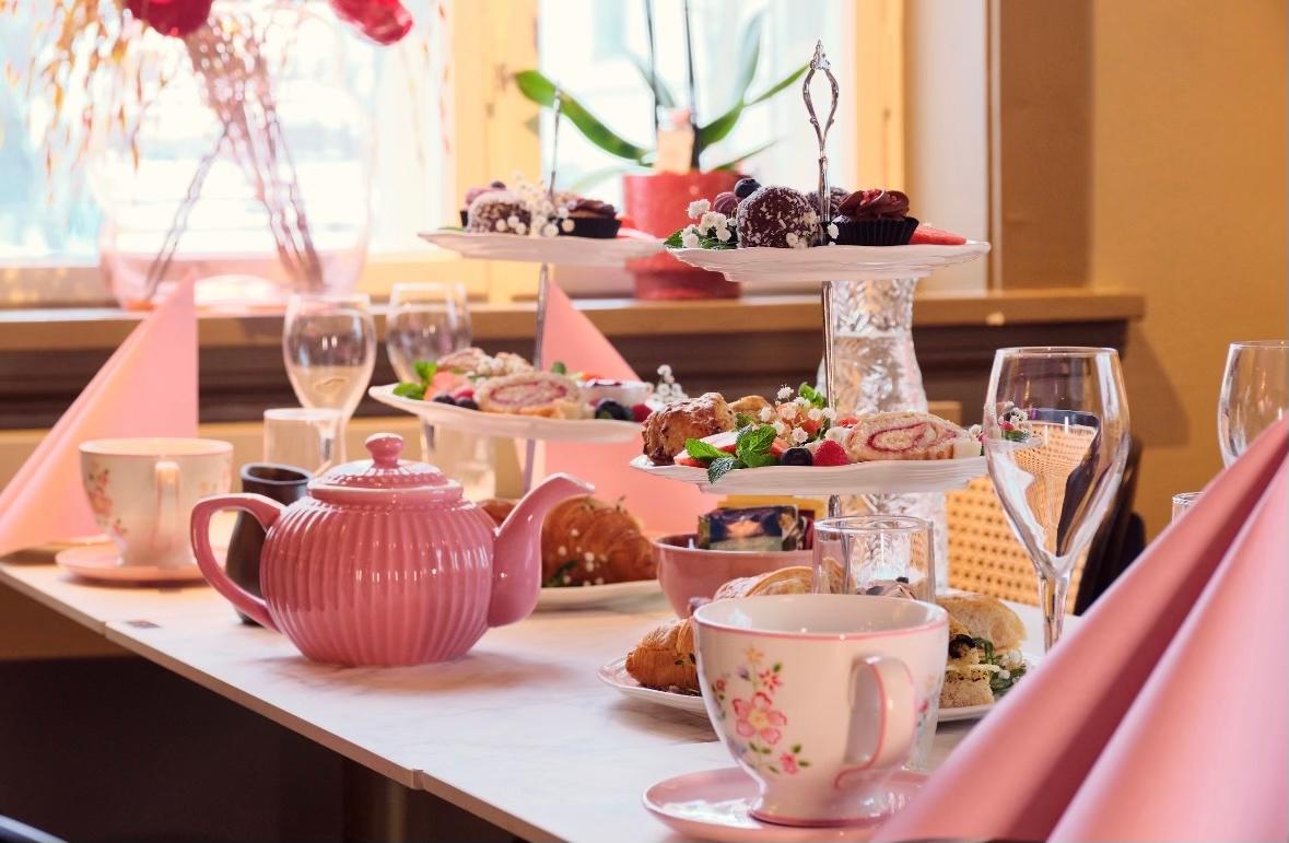 rosa te kopper og kanne på et dekket bord