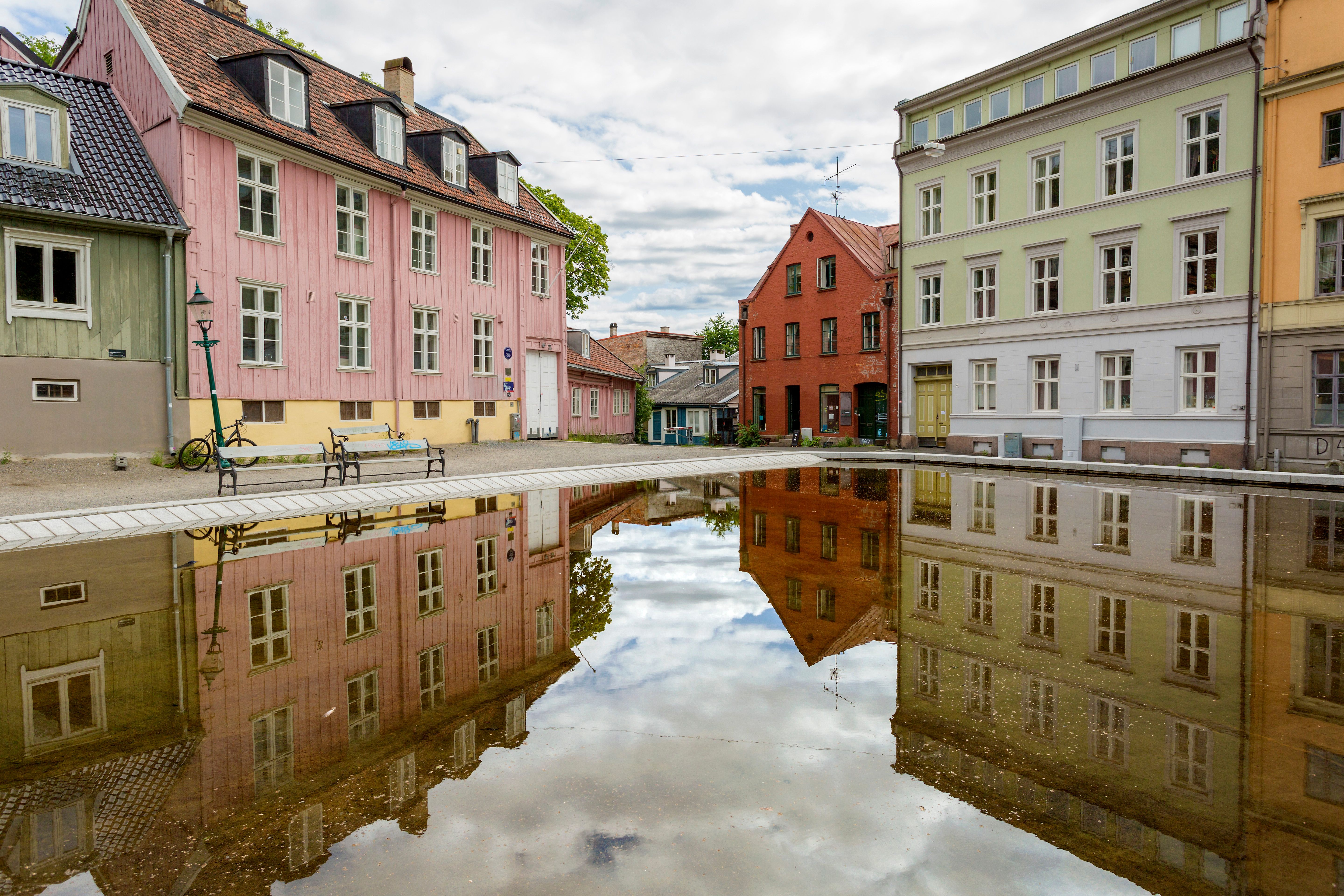 Gamle trehus rundt en plass med et basseng.