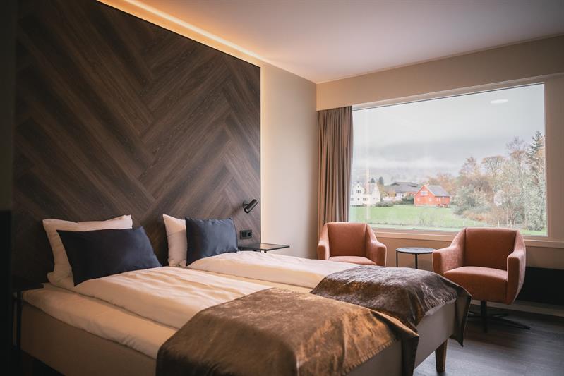 Komfortabelt hotellrom på Rosendal Fjordhotel med sittegruppe og fjordutsikt