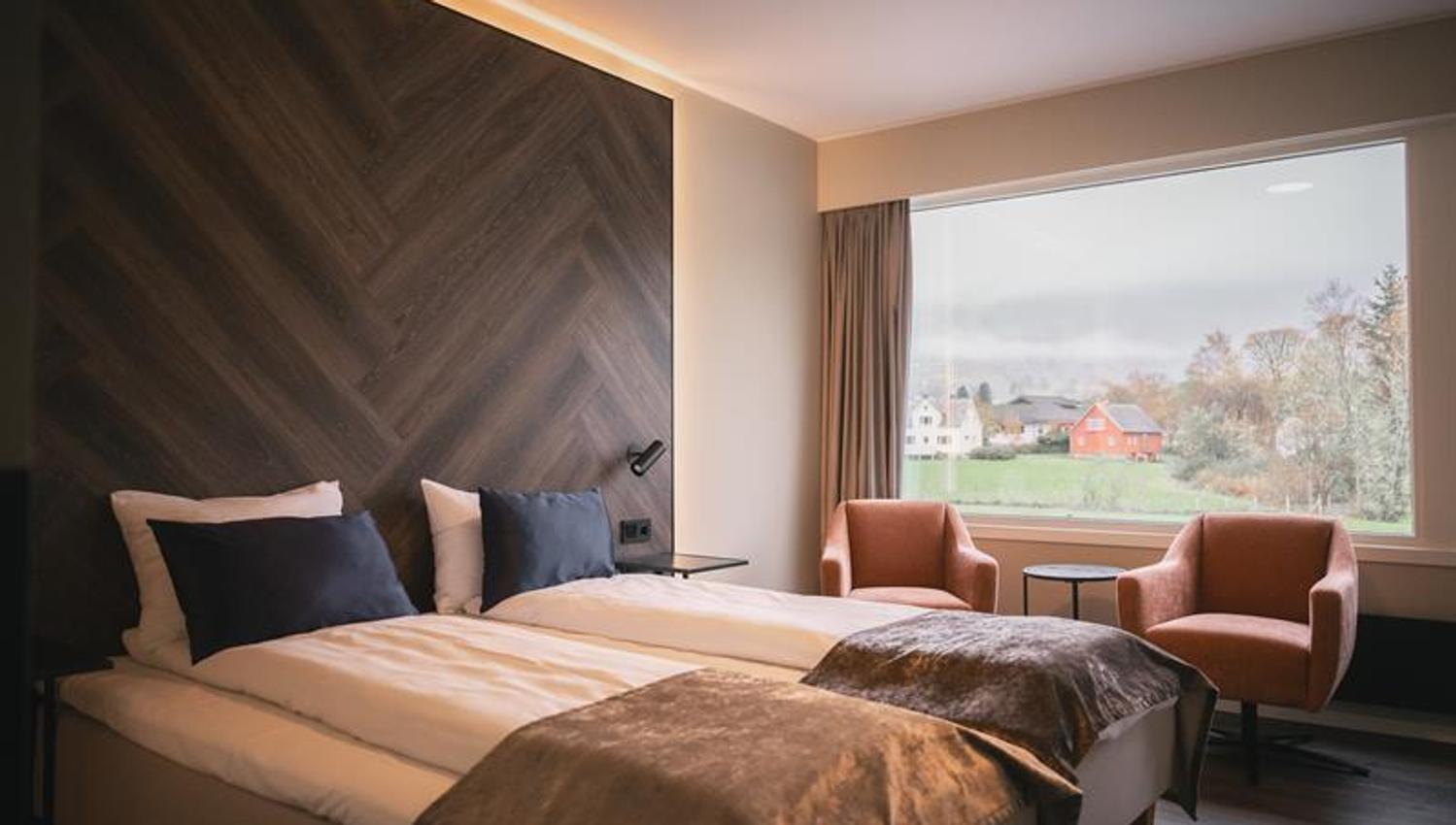 Komfortabelt hotellrom på Rosendal Fjordhotel med sittegruppe og fjordutsikt