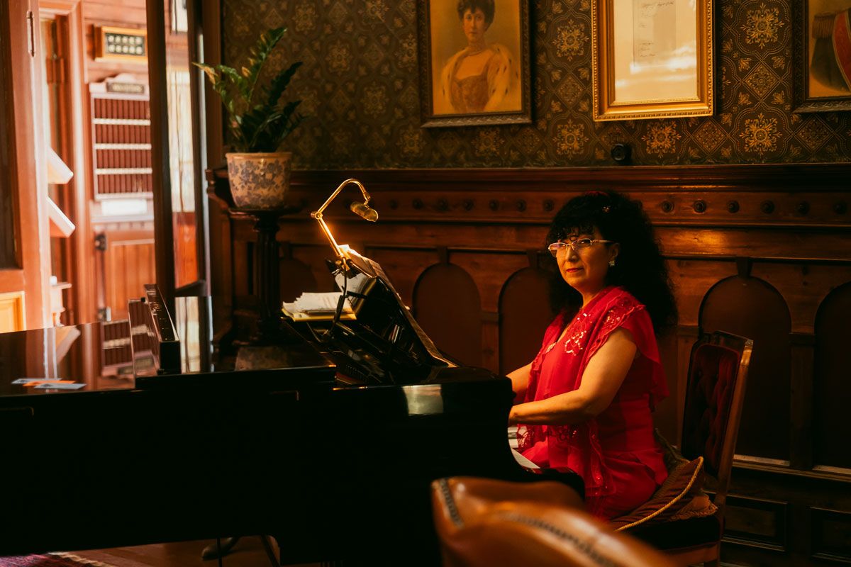 A lady is sitting at the piano at the Dalen Hotel