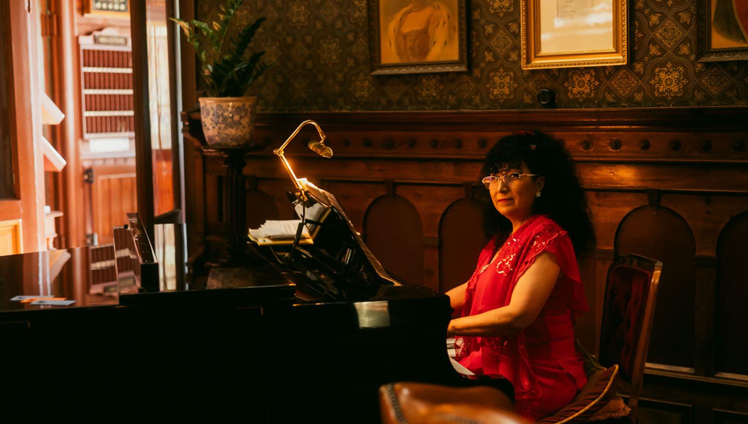 A lady is sitting at the piano at the Dalen Hotel